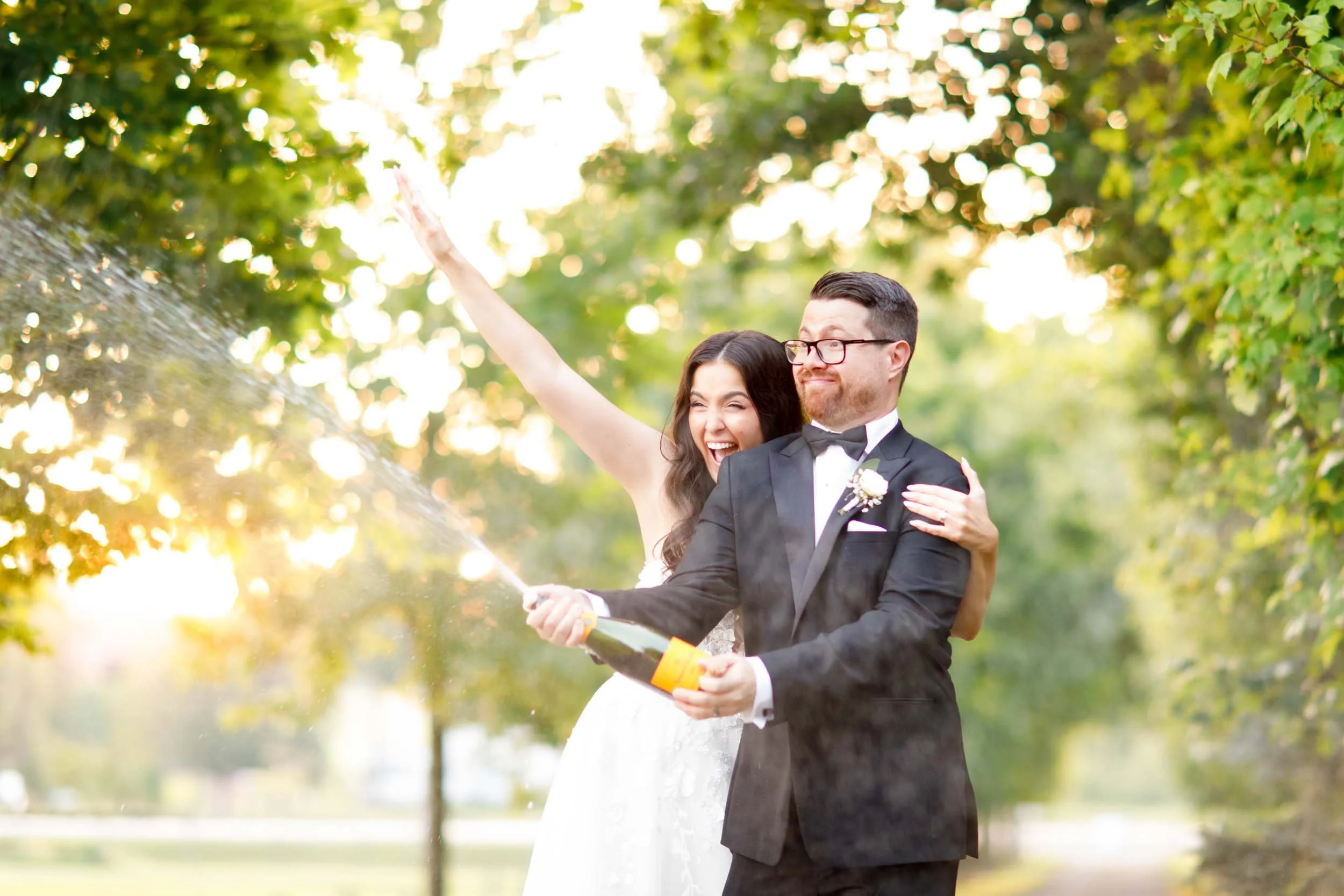 Bride and groom smiling while holding champagne at Cambium Farms in Alton, Ontario