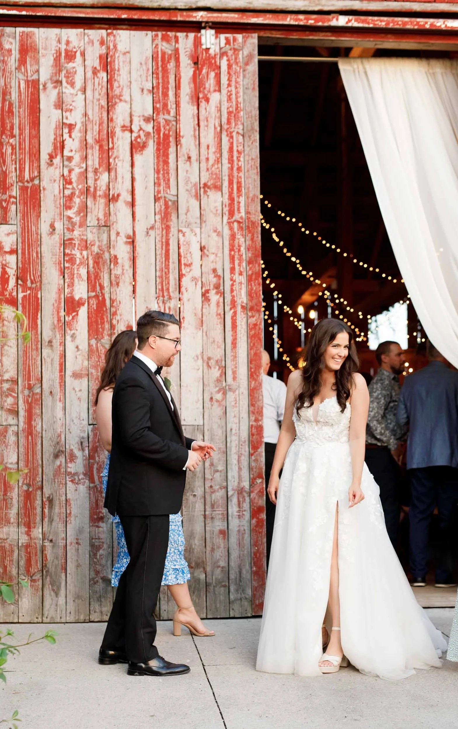 Bride and groom stepping outside the Cambium Farms barn after the reception in Alton, Ontario