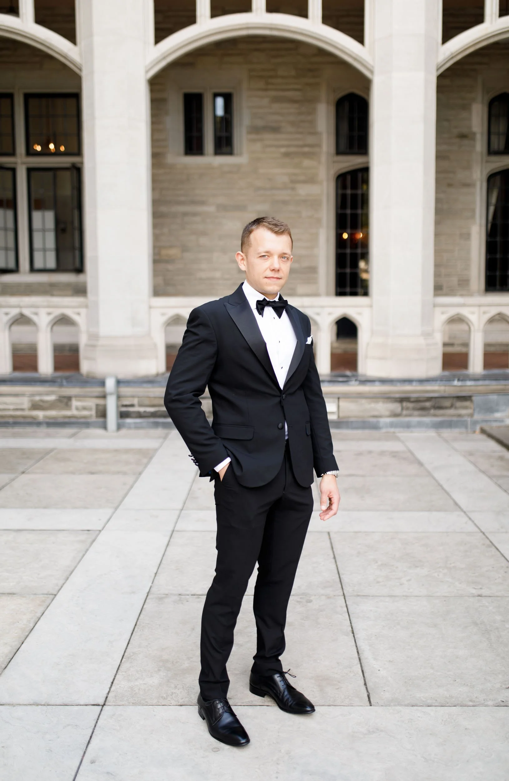 Groom standing under the arches at Casa Loma in Toronto