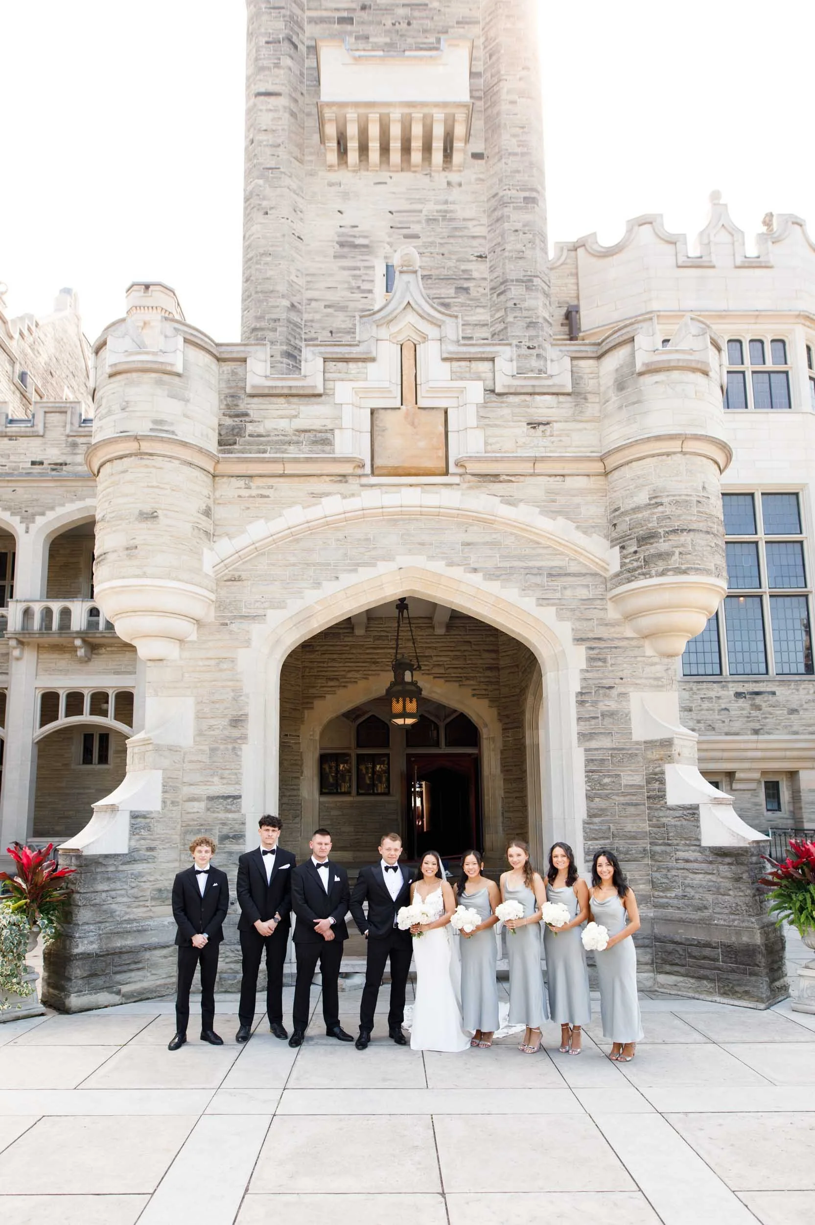 Wedding party standing in front of Casa Loma in Toronto