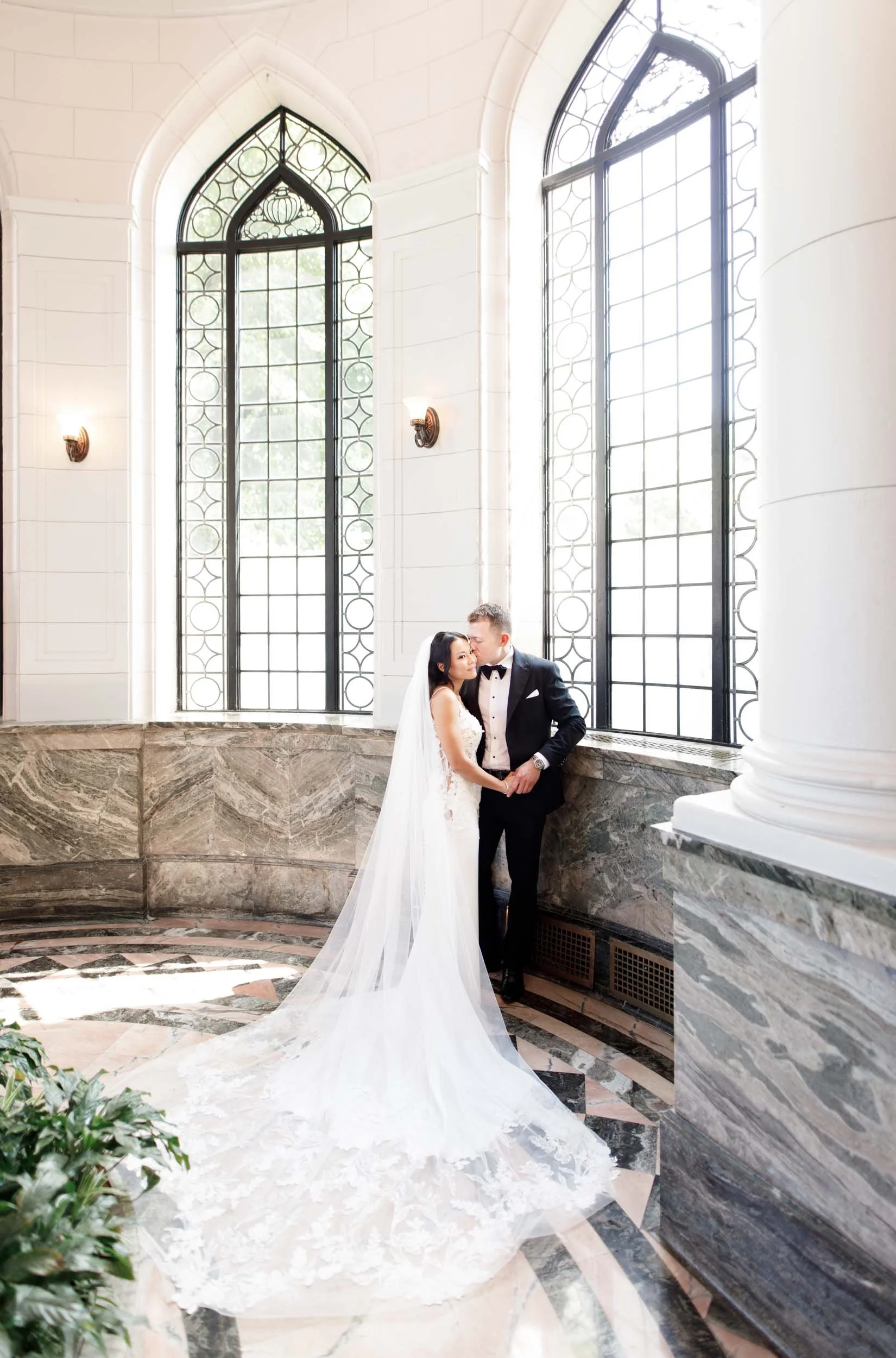 Bride and groom with flowing veil in the Casa Loma conservatory