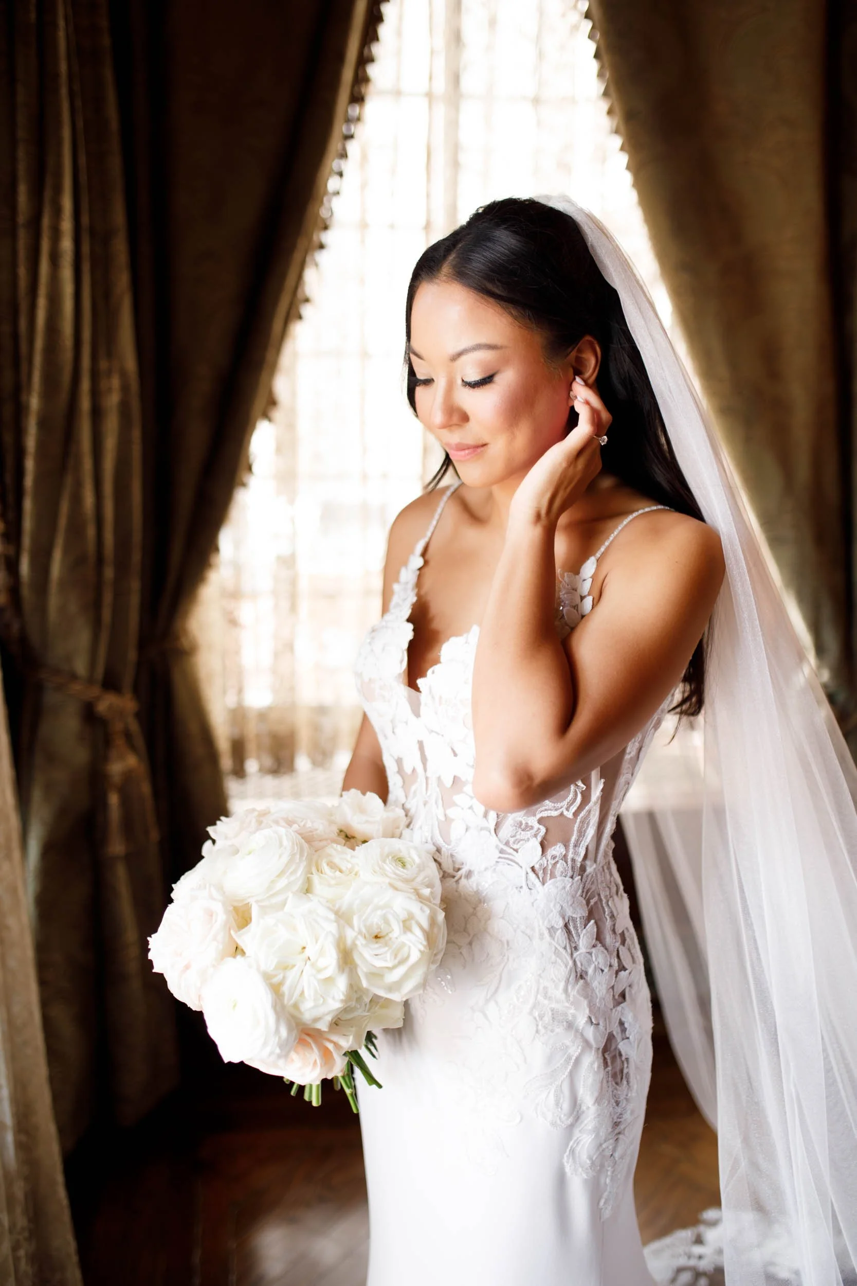Bride looking down with her bouquet at Casa Loma