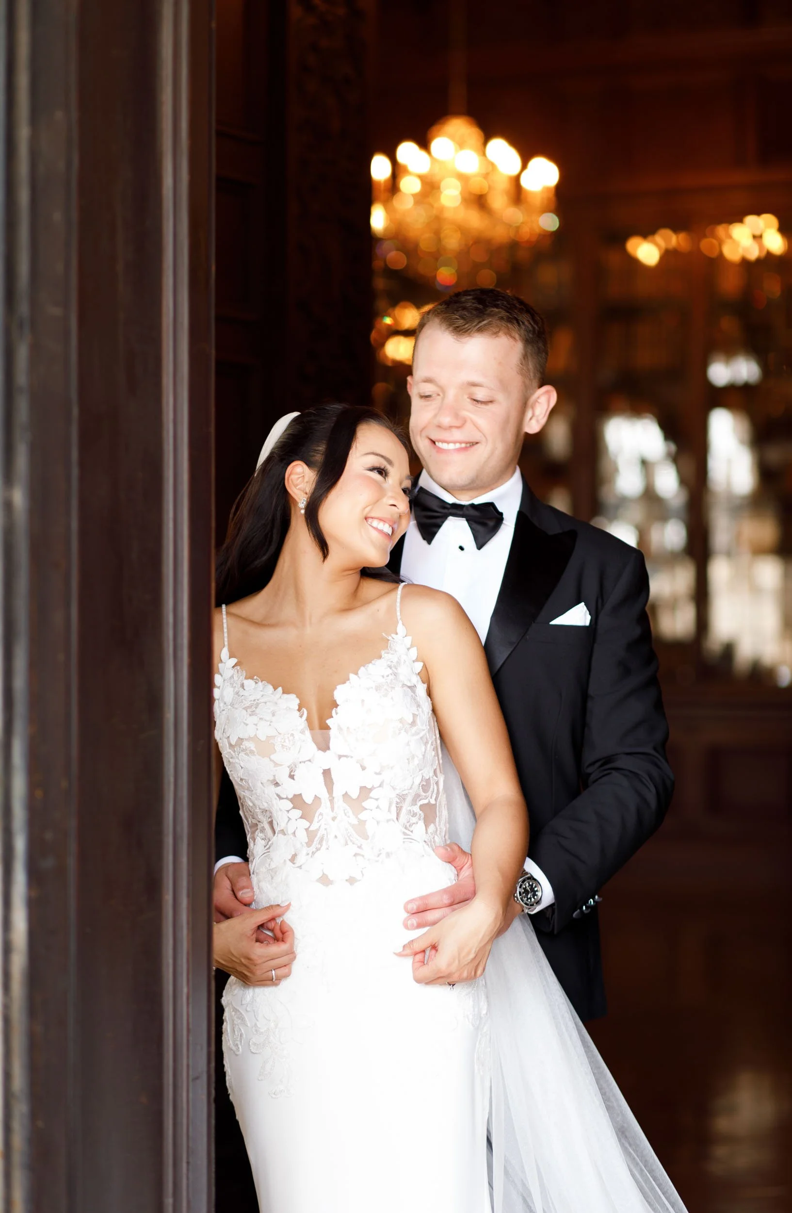 Bride and groom posing under the chandeliers at Casa Loma