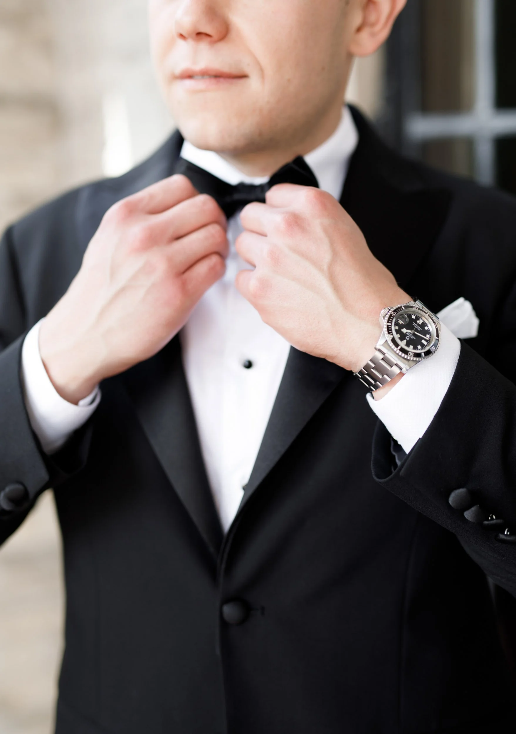 Groom adjusting his bow tie at Casa Loma