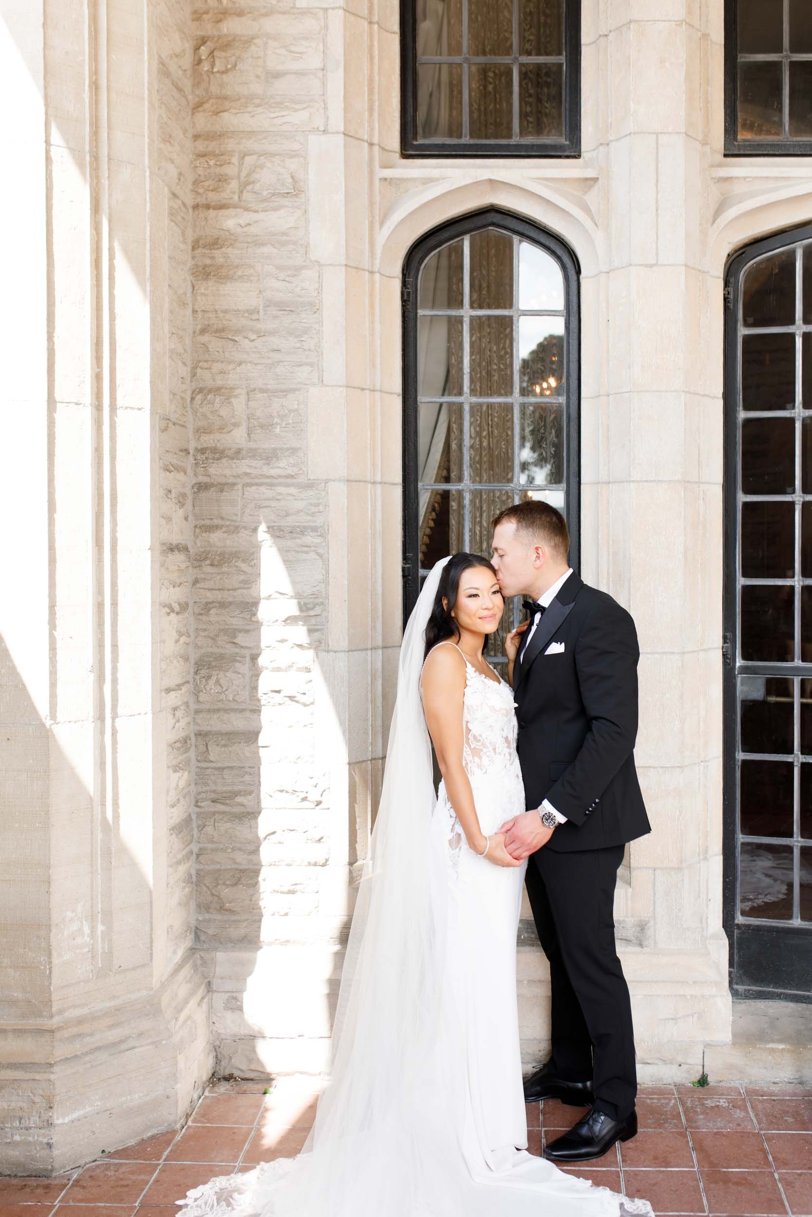 Bride and groom under the Casa Loma stone arches