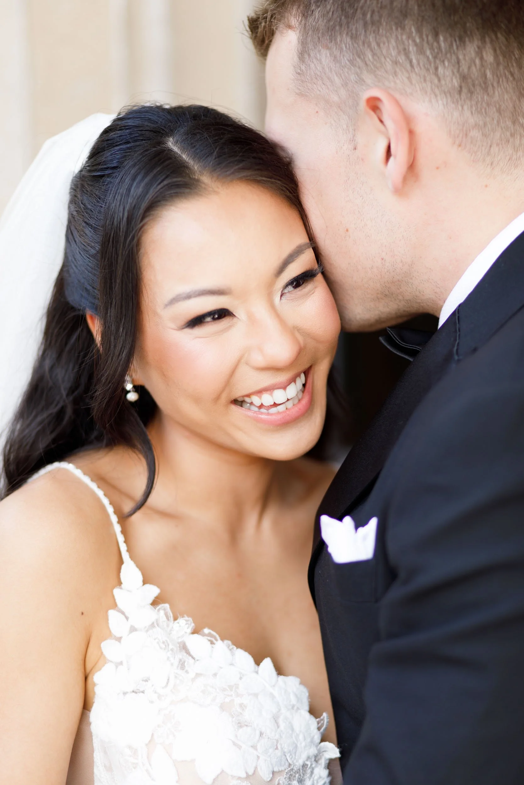 Bride smiling as the groom kisses her at Casa Loma