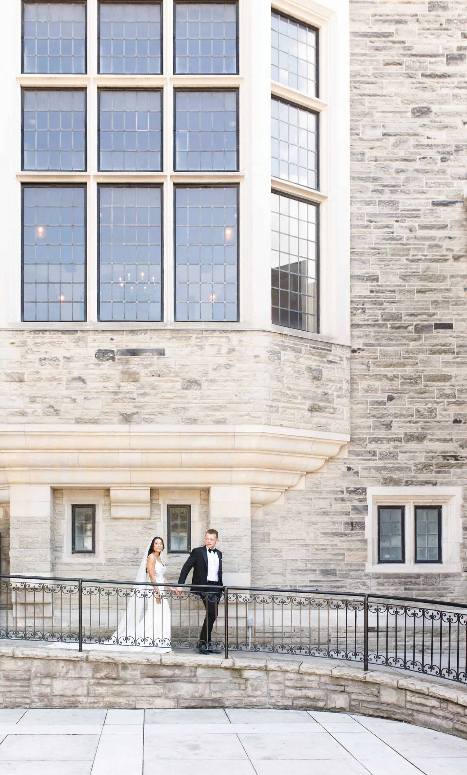 Bride and groom standing on the Casa Loma balcony in Toronto during their wedding