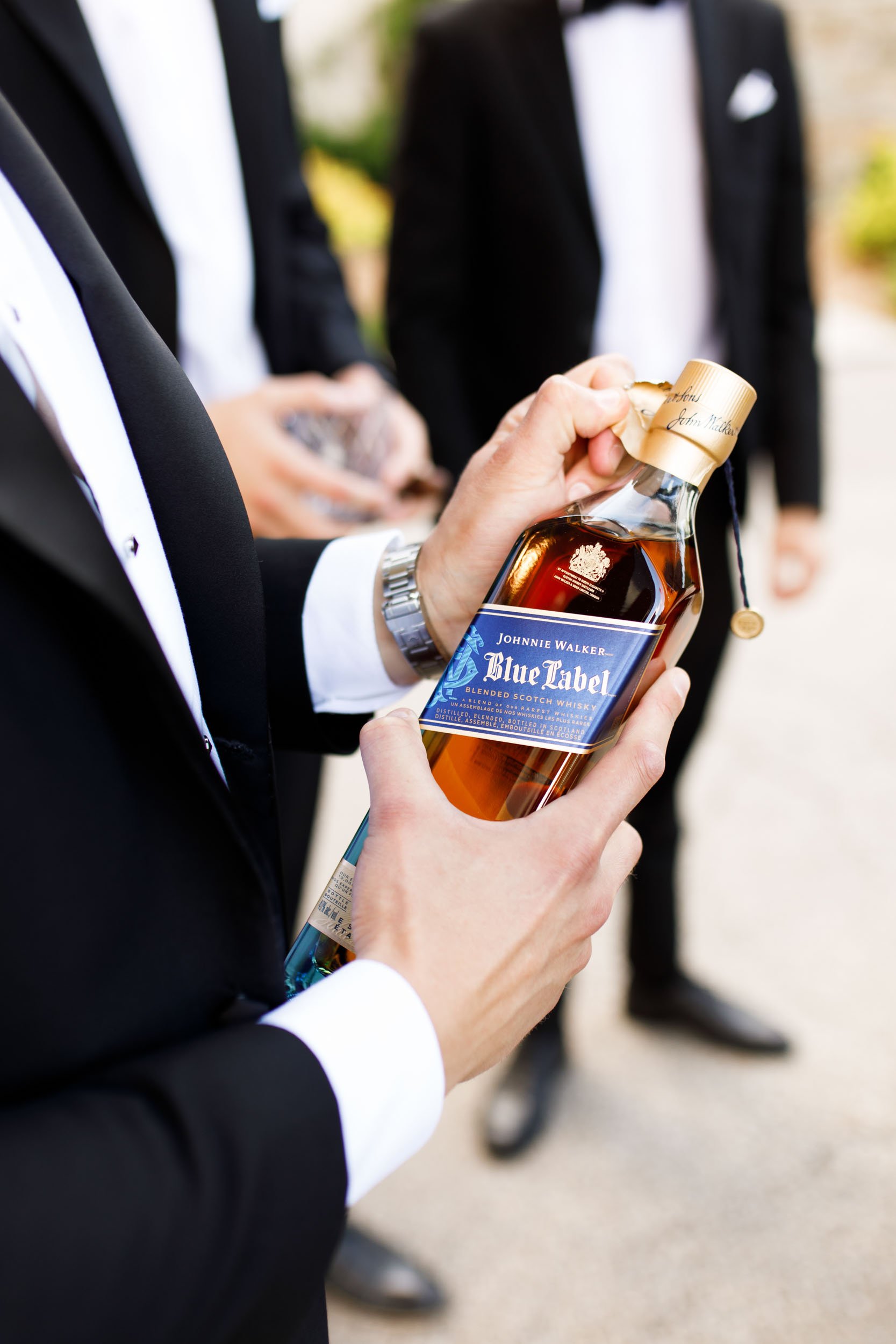 Groomsmen holding a bottle of Johnny Walker at a St. George’s Golf Club wedding in Toronto