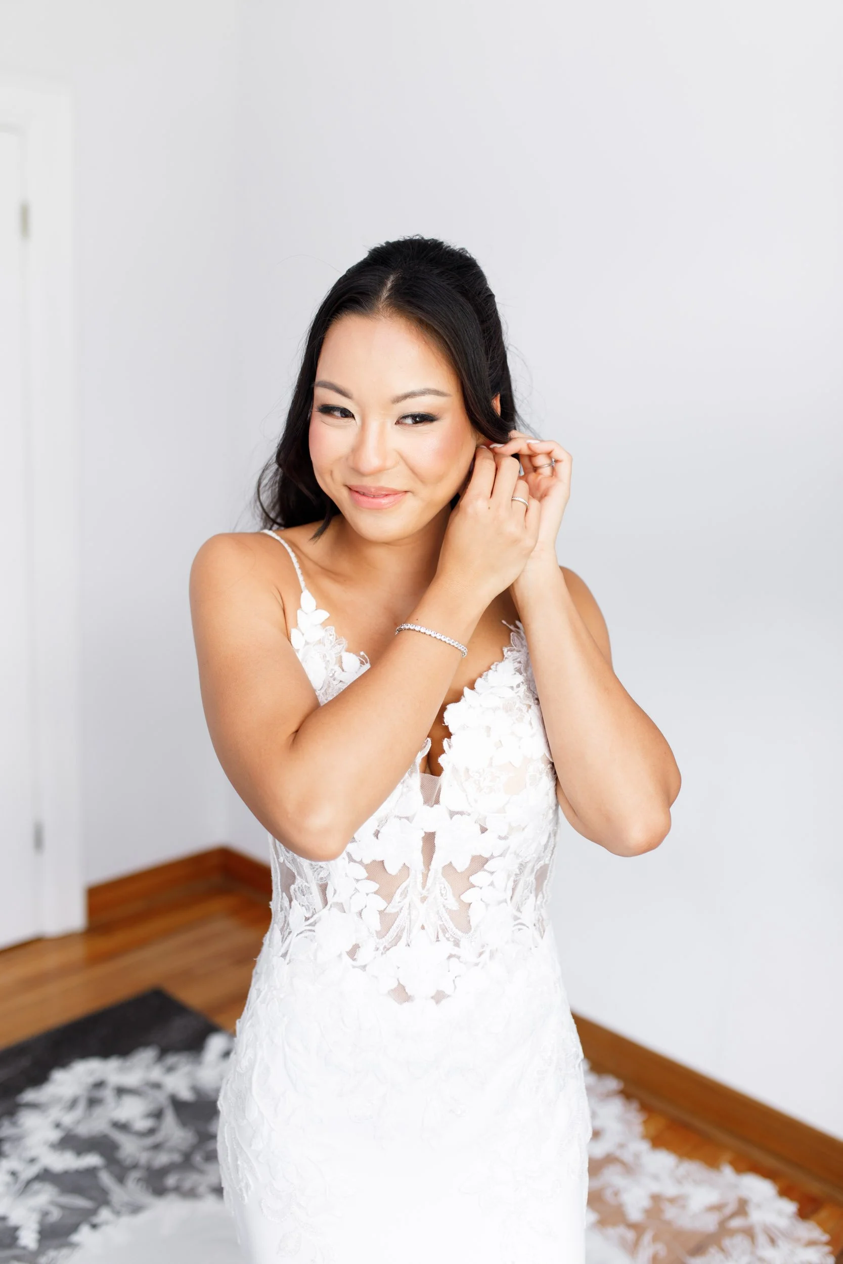 Bride putting on her earrings during Toronto wedding prep
