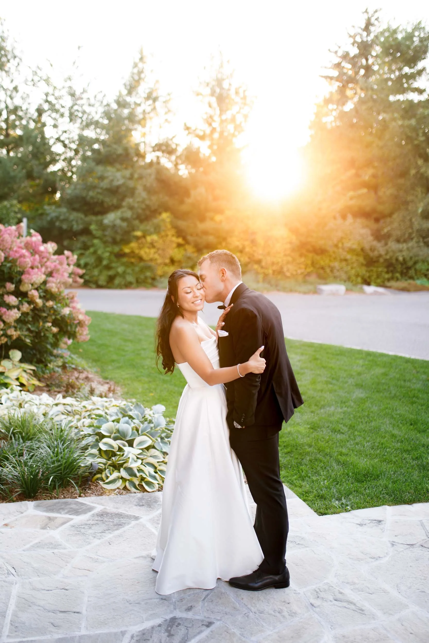 Bride and groom kissing in golden sunset light at St. George’s Golf and Country Club in Toronto