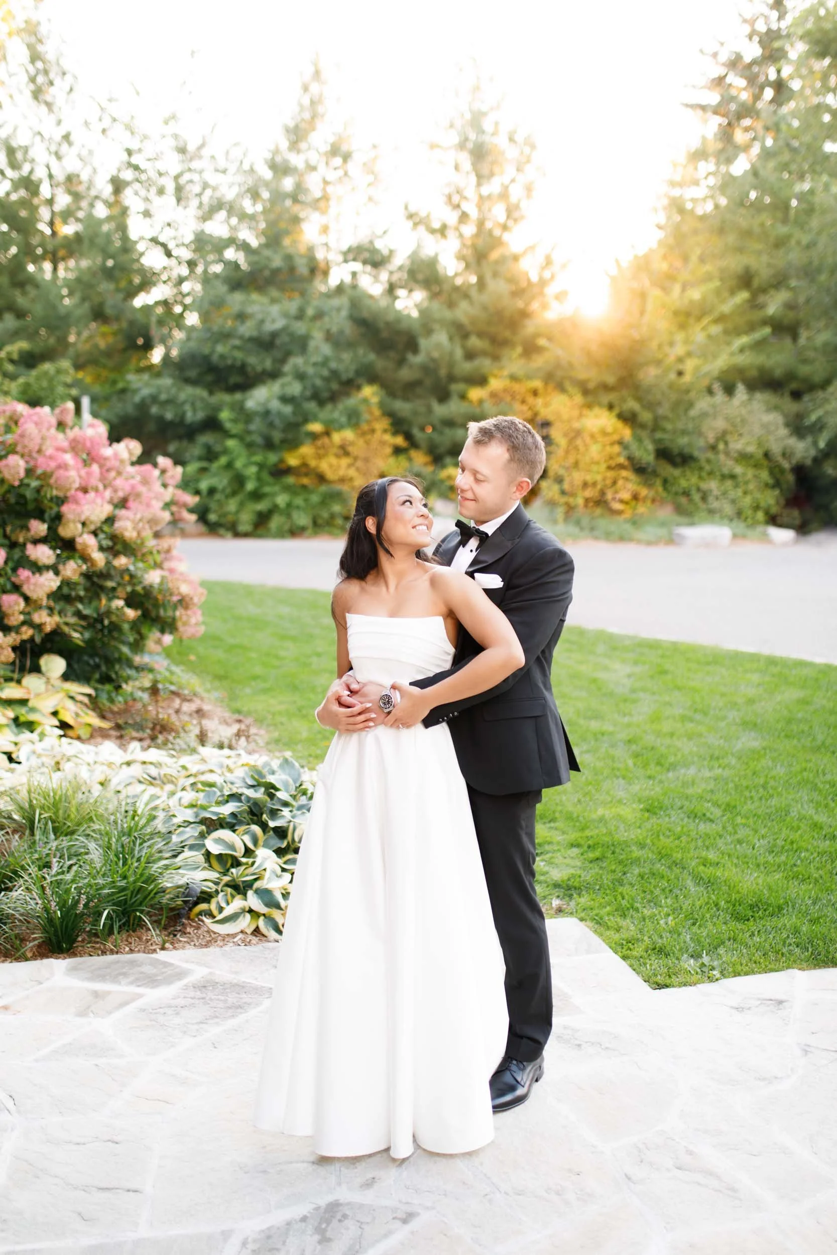 Bride and groom holding each other on the stone patio at St. George’s Golf and Country Club in Toronto