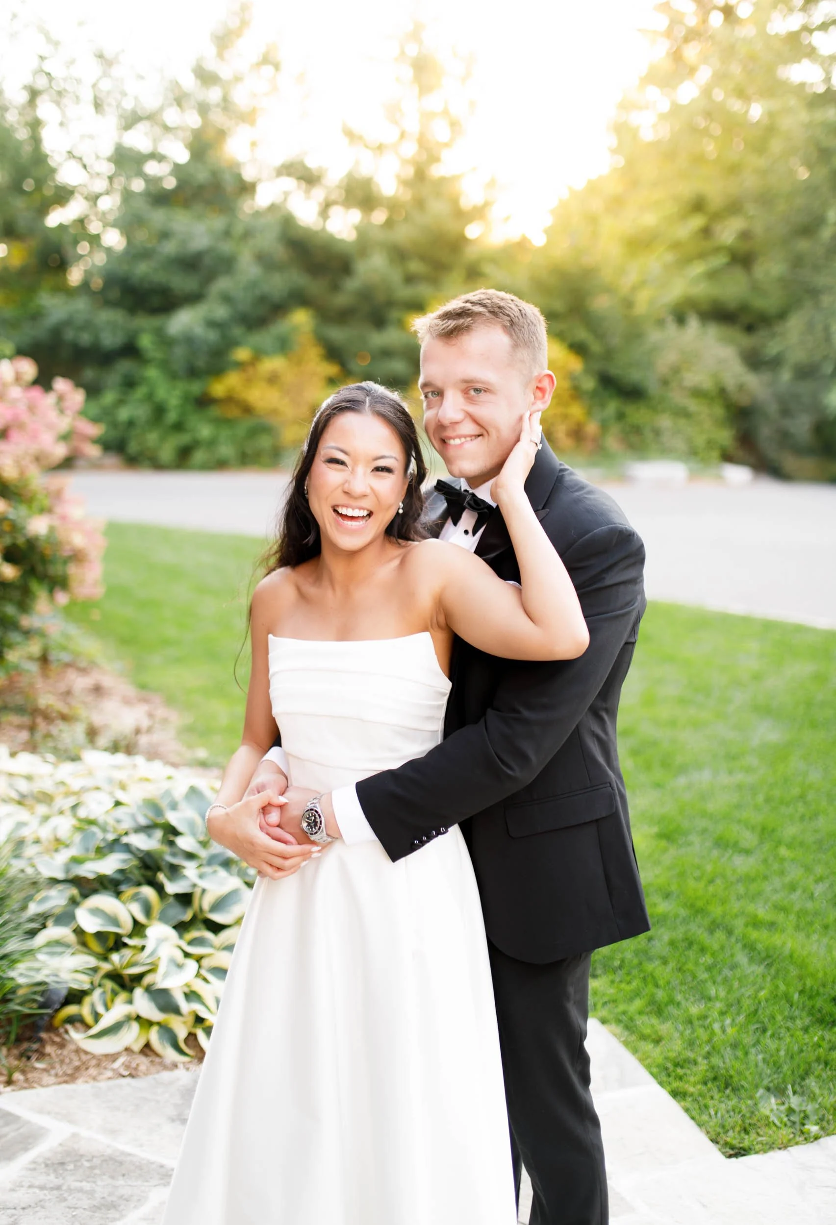 Bride smiling as the groom embraces her at St. George’s Golf Club in Toronto