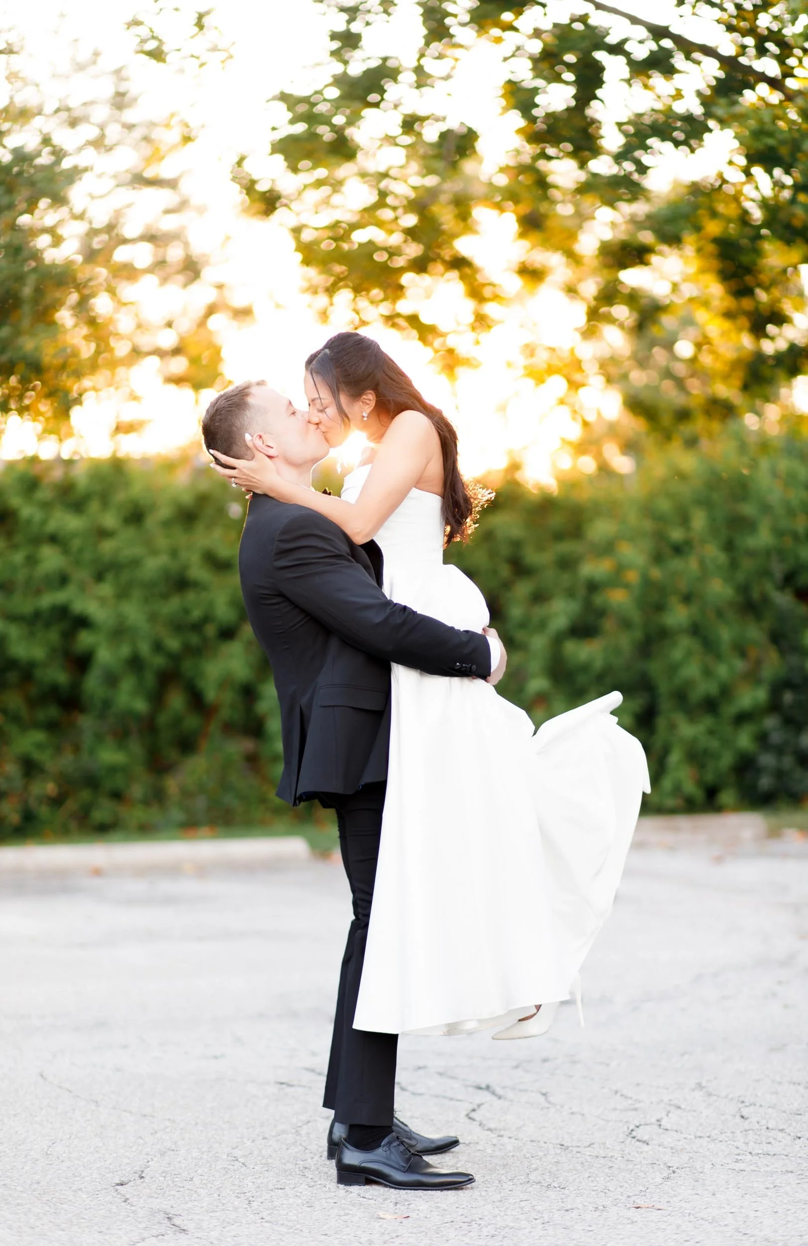 Bride and groom kissing while lifted during a St. George’s Golf Club wedding in Toronto