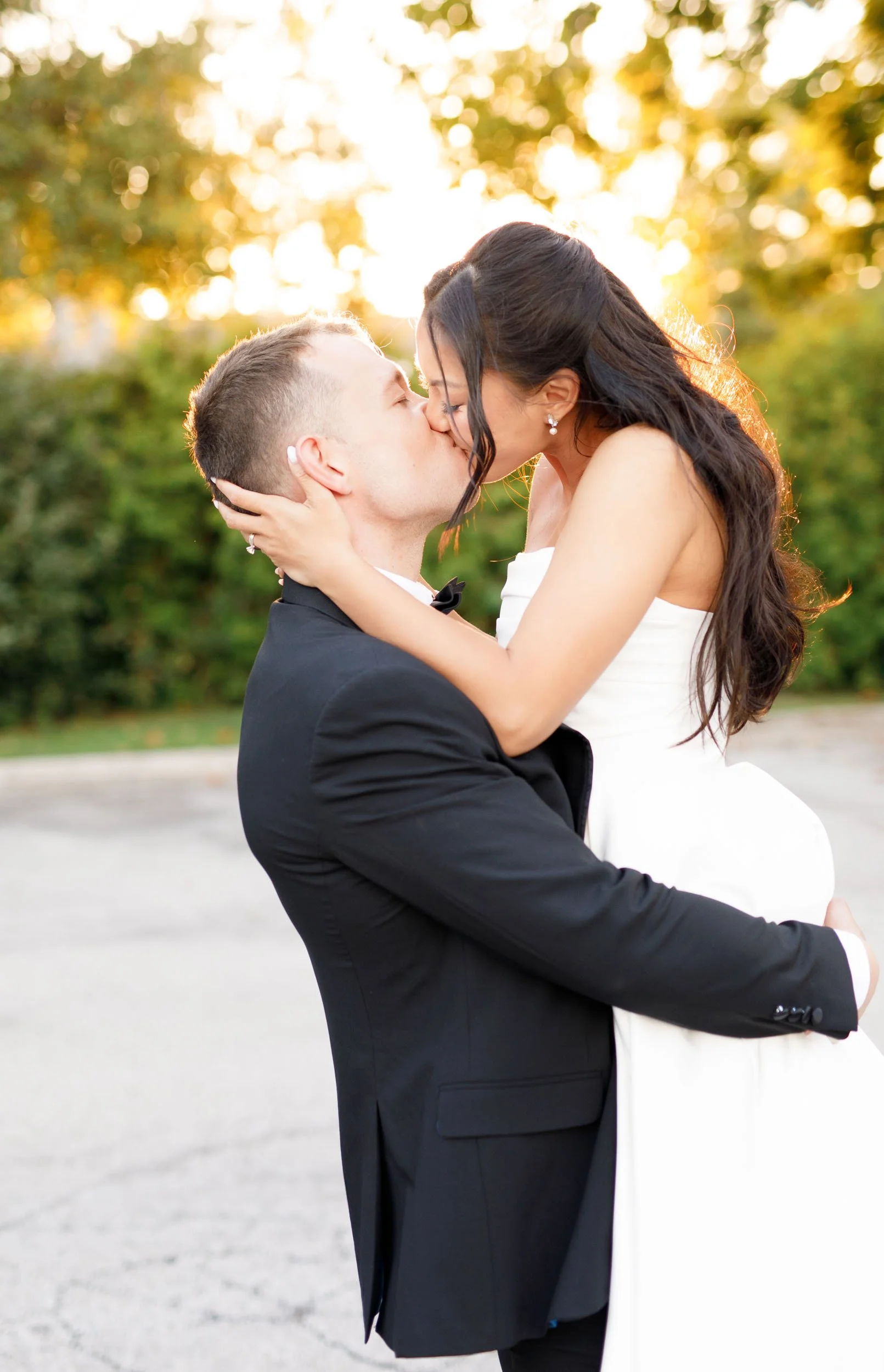Bride kissing the groom as he lifts her during their St. George’s Golf Club wedding in Toronto