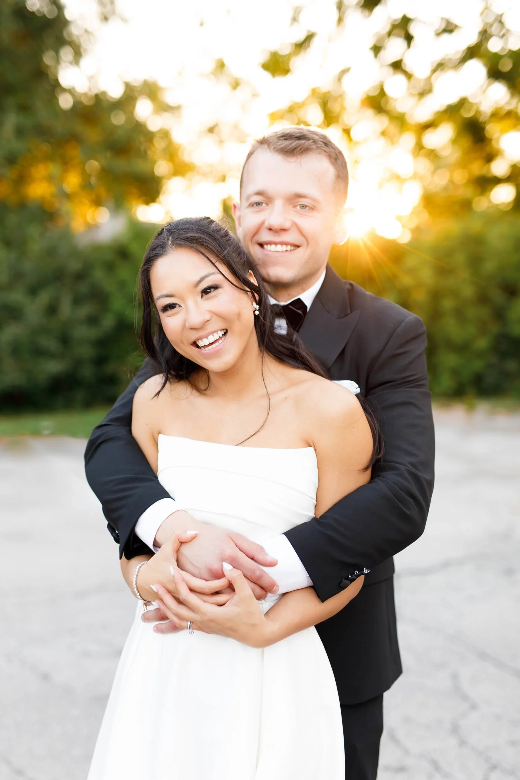 Bride leaning back into the groom while laughing at St. George’s Golf Club in Toronto