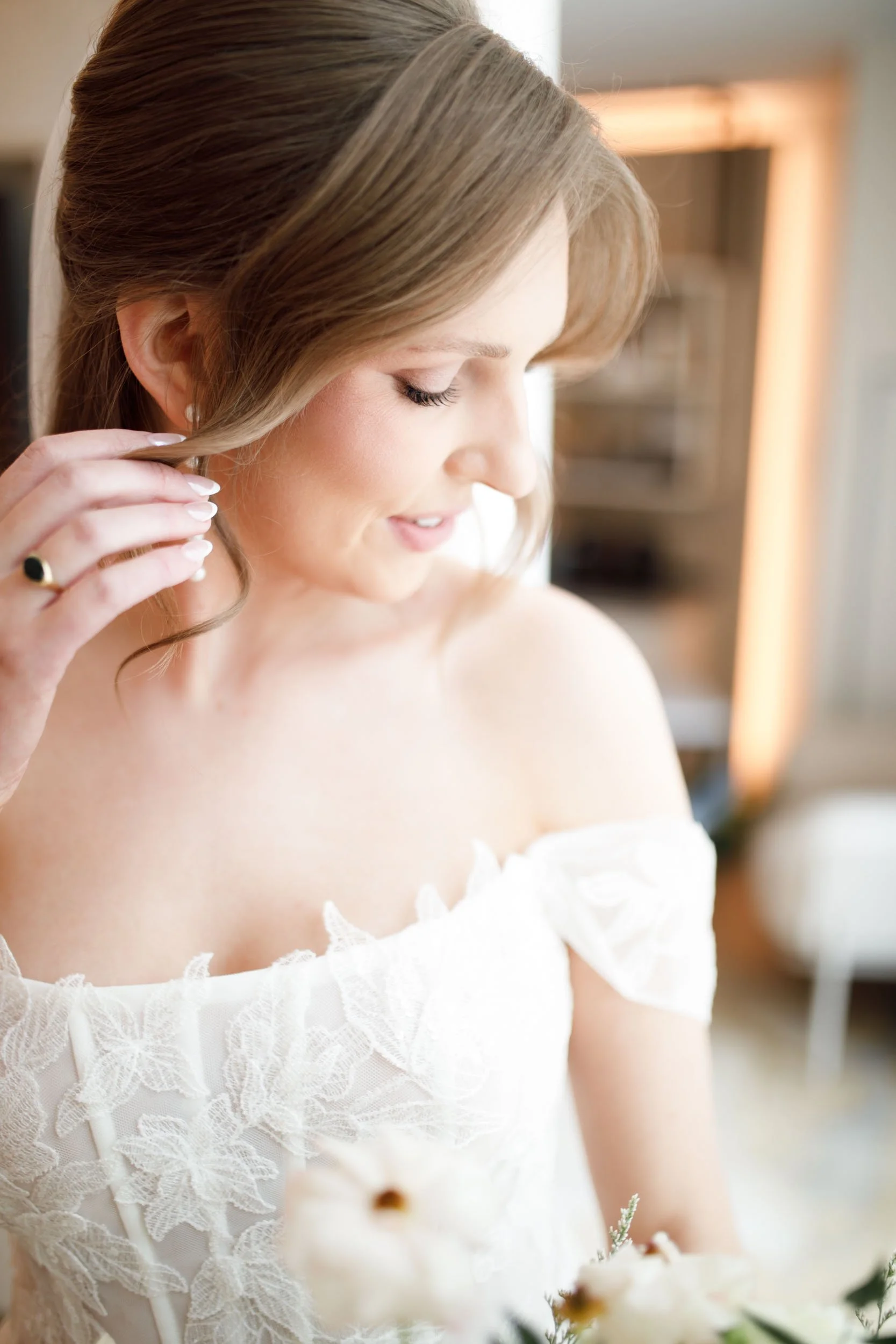Bride putting on her earrings in a hotel suite at the Pearle Hotel in Burlington Ontario