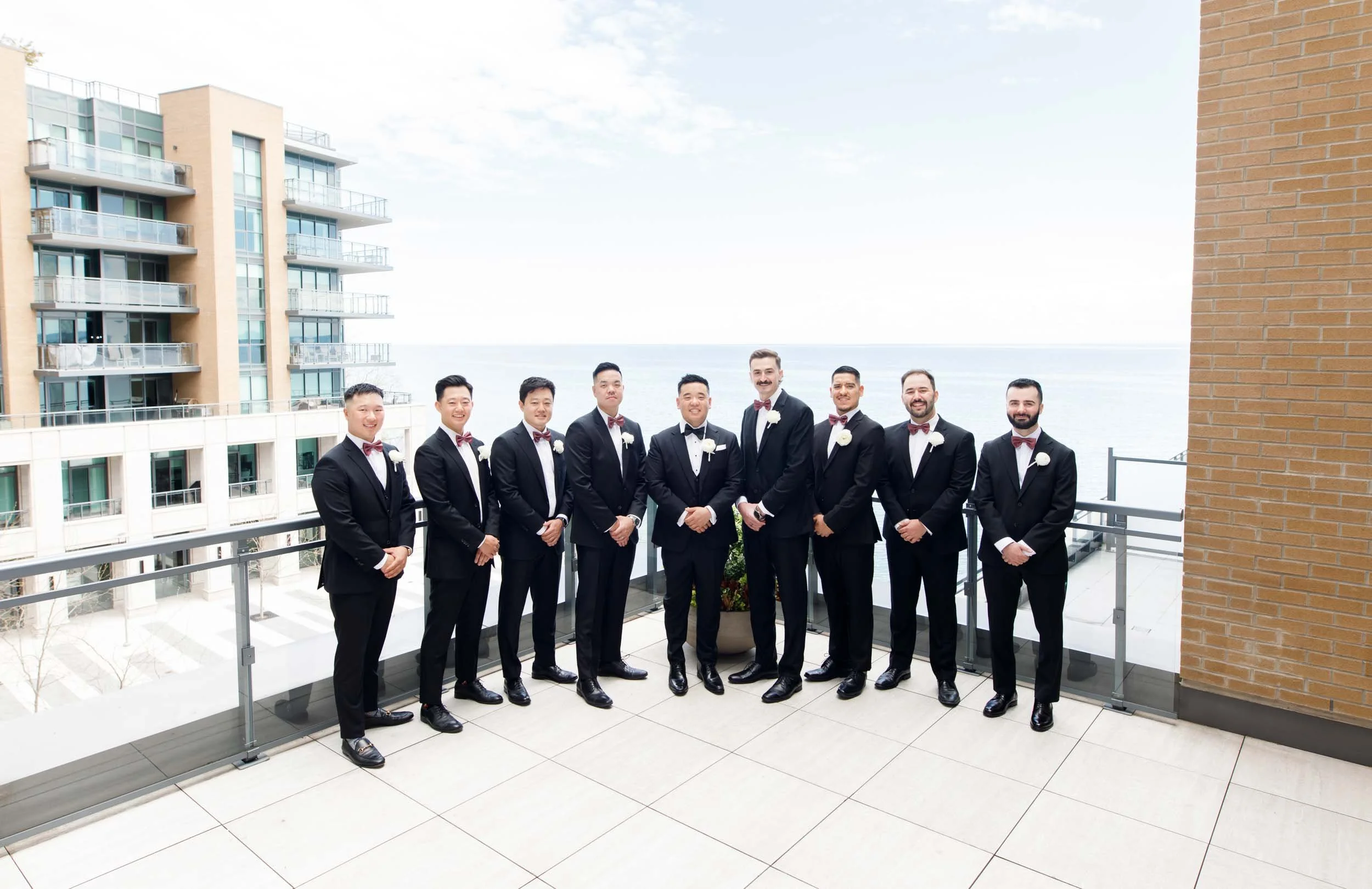 Groomsmen lined up on the waterfront terrace at the Pearle Hotel in Burlington Ontario