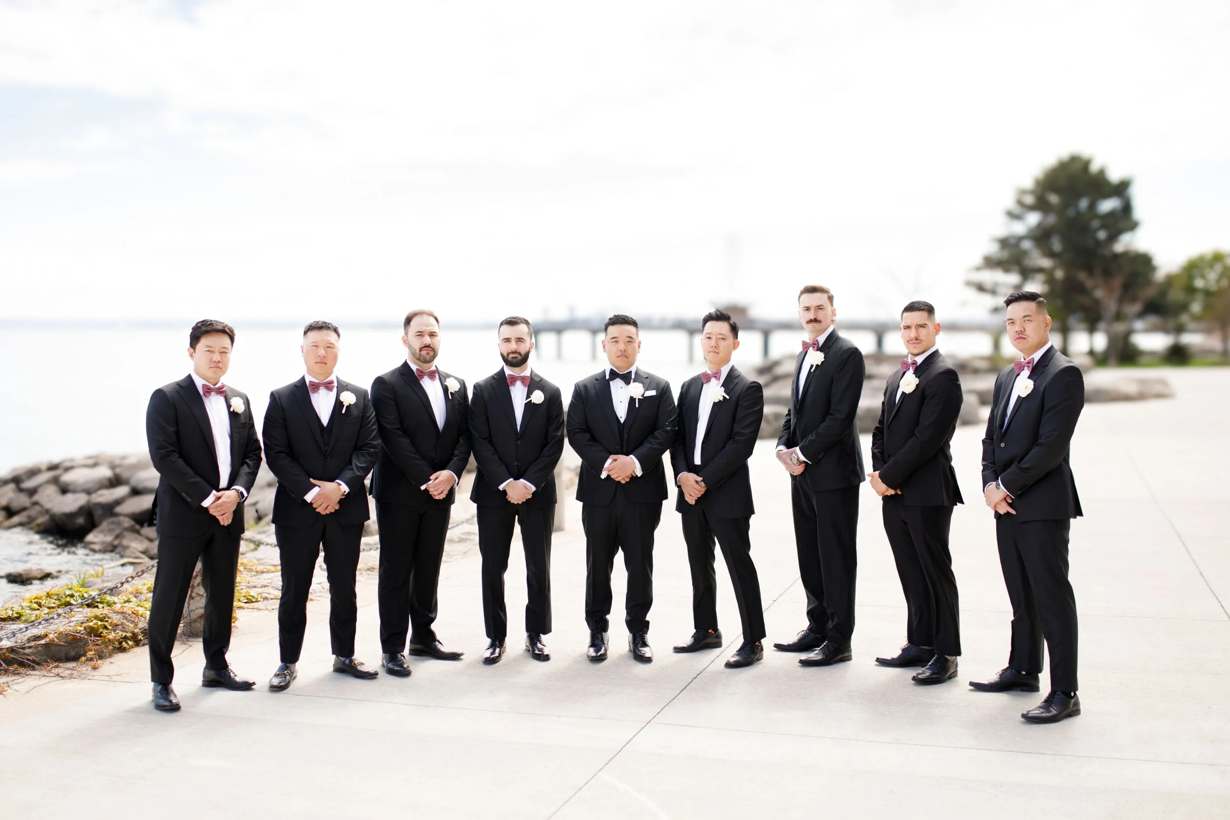 Groomsmen posing by the waterfront at the Pearle Hotel in Burlington Ontario