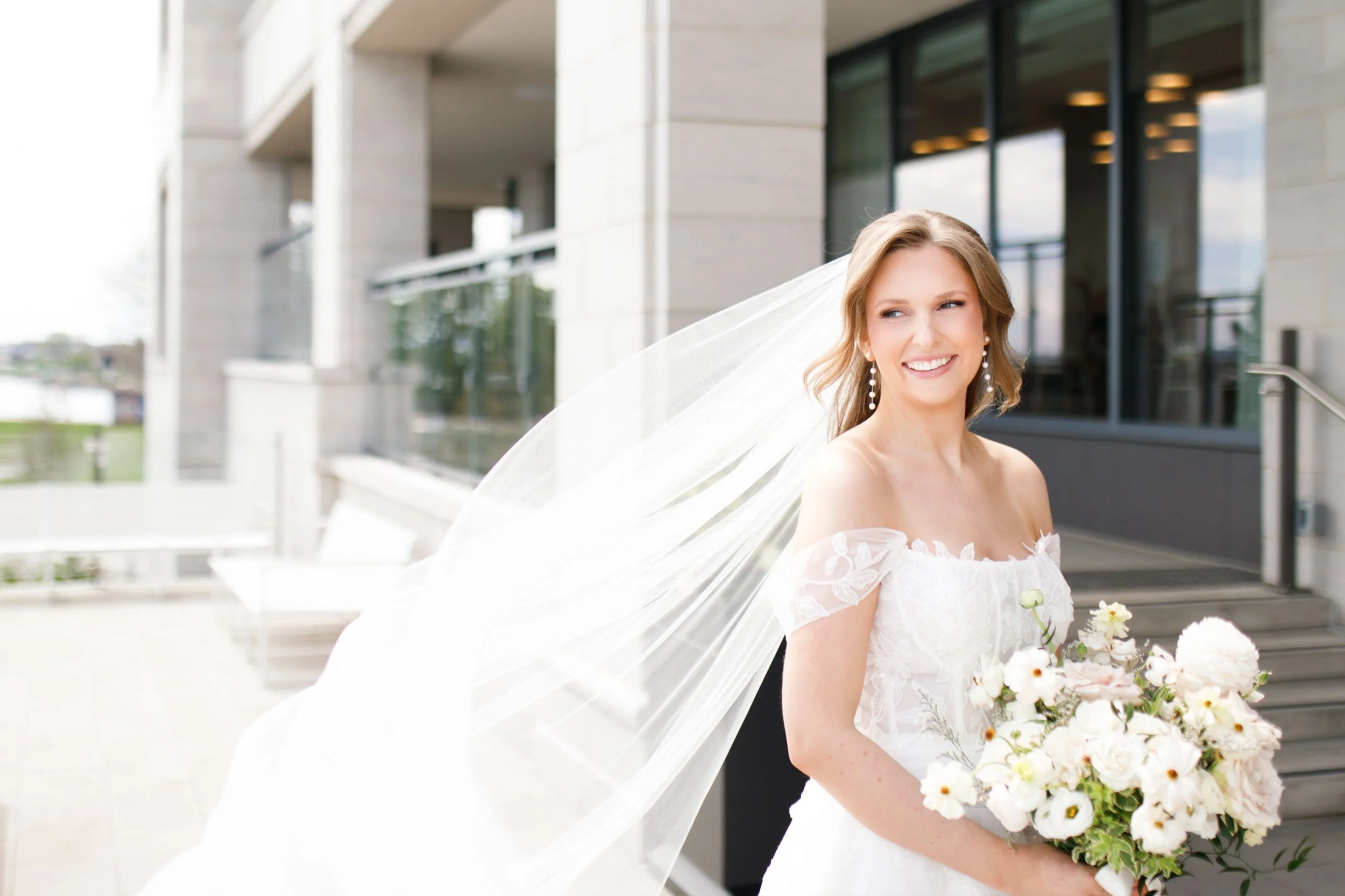 Bride holding her bouquet with her veil blowing at the Pearle Hotel in Burlington Ontario