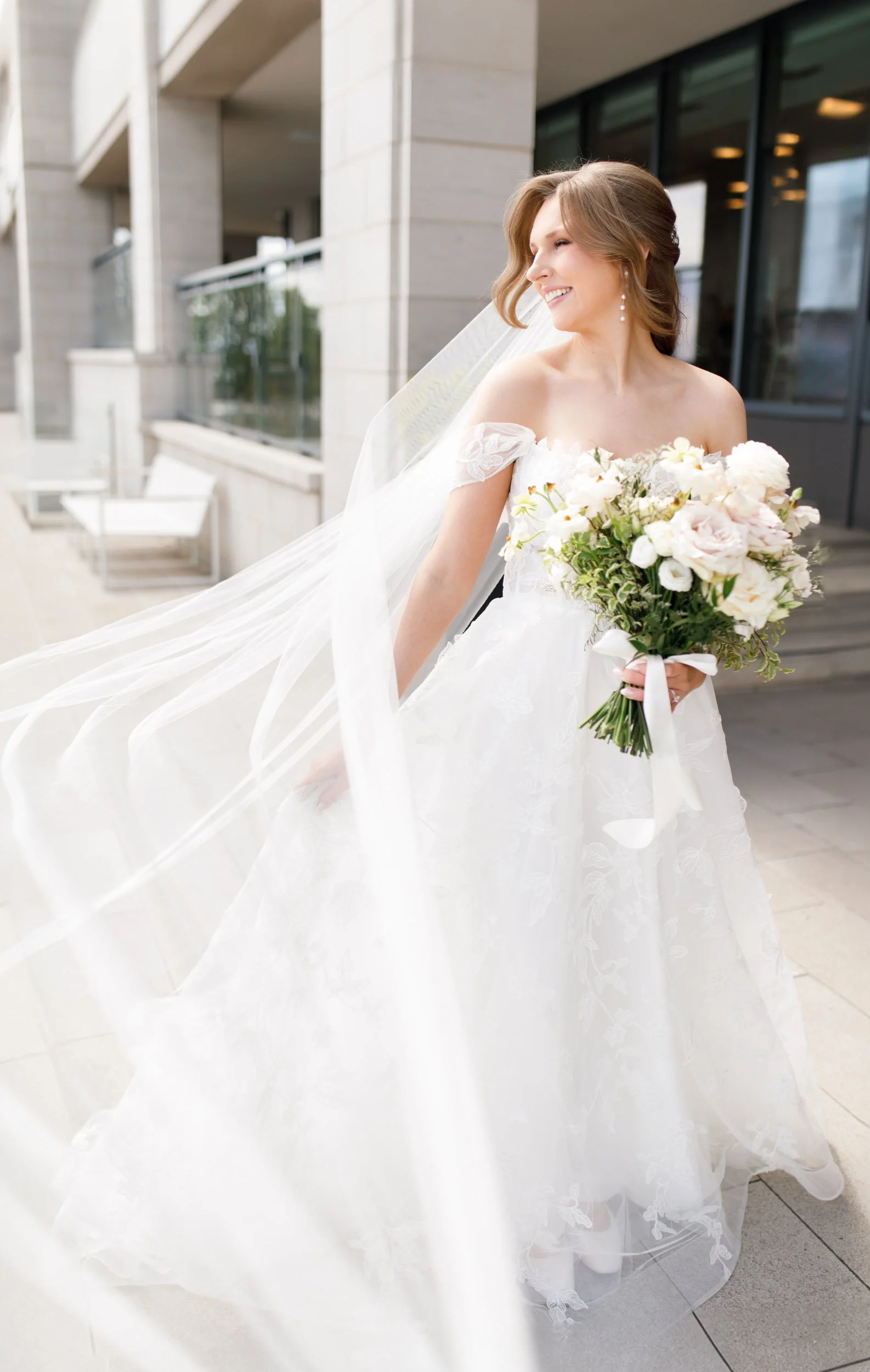 Bride walking outside the Pearle Hotel in Burlington Ontario with her veil