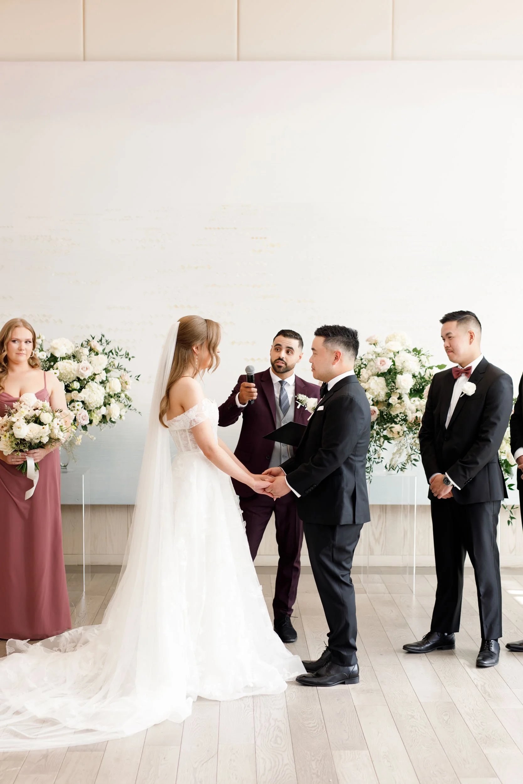 Bride and groom holding hands during their ceremony at the Pearle Hotel in Burlington Ontario