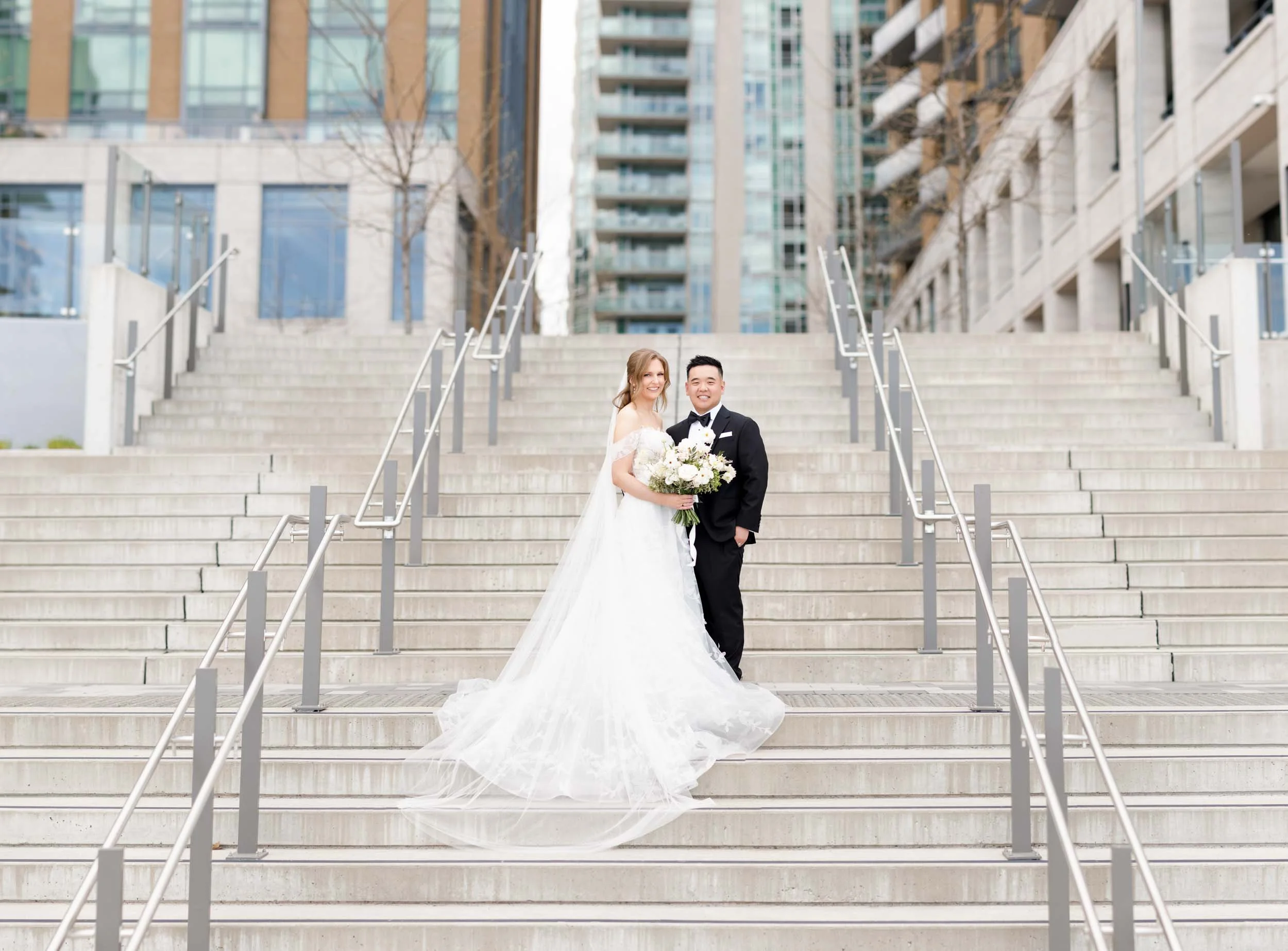 Wide shot of the bride and groom on the Pearle Hotel stairs in Burlington Ontario