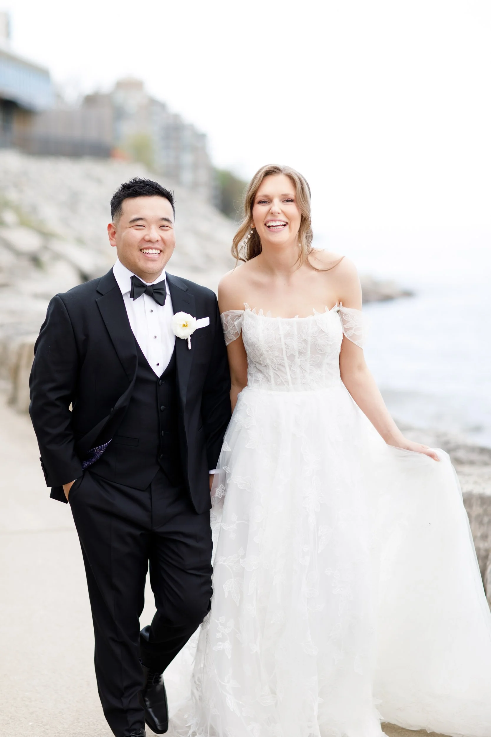 Bride and groom smiling together by the lake at the Pearle Hotel in Burlington Ontario