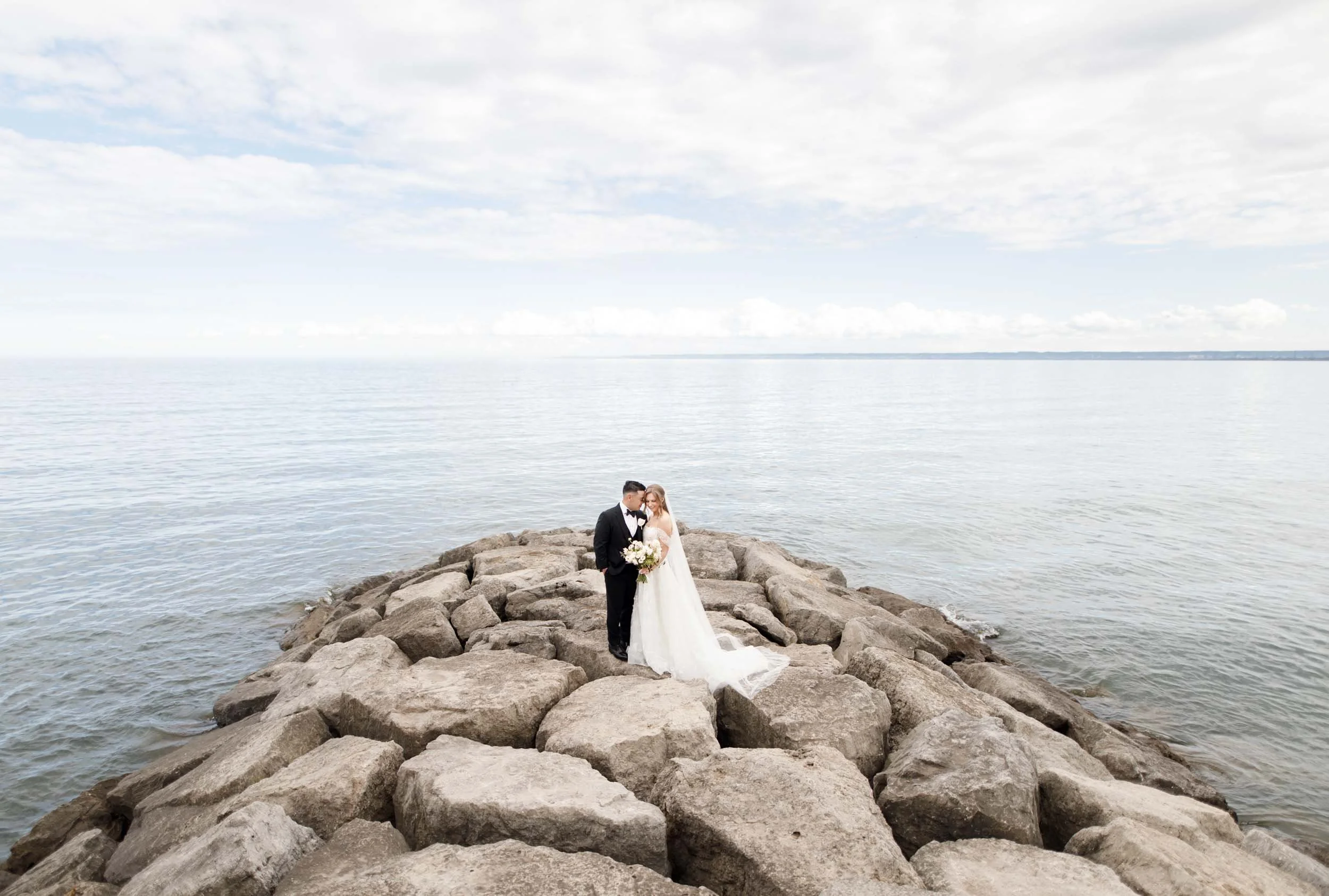 Wide waterfront portrait of the bride and groom at the Pearle Hotel in Burlington Ontario