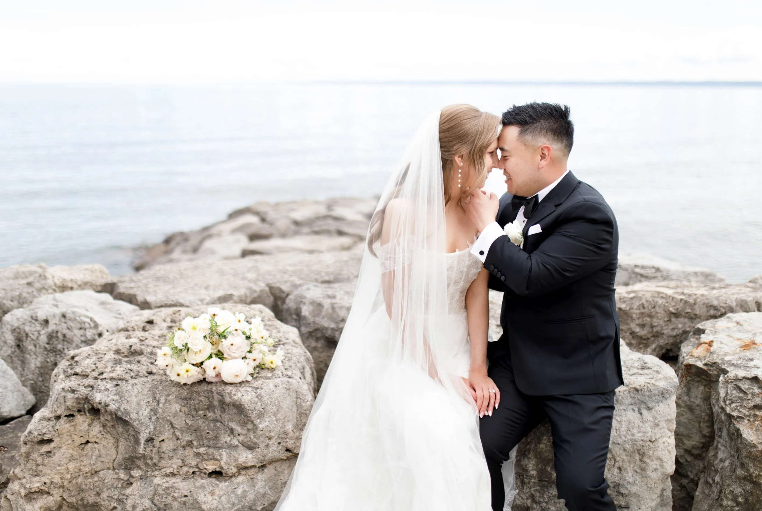 Bride and groom sharing a kiss by the water at the Pearle Hotel in Burlington Ontario
