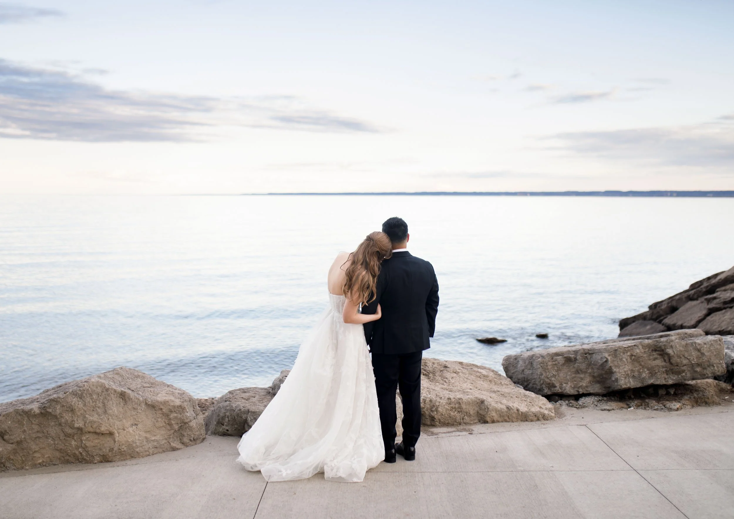 Bride and groom embracing on the waterfront at the Pearle Hotel in Burlington Ontario