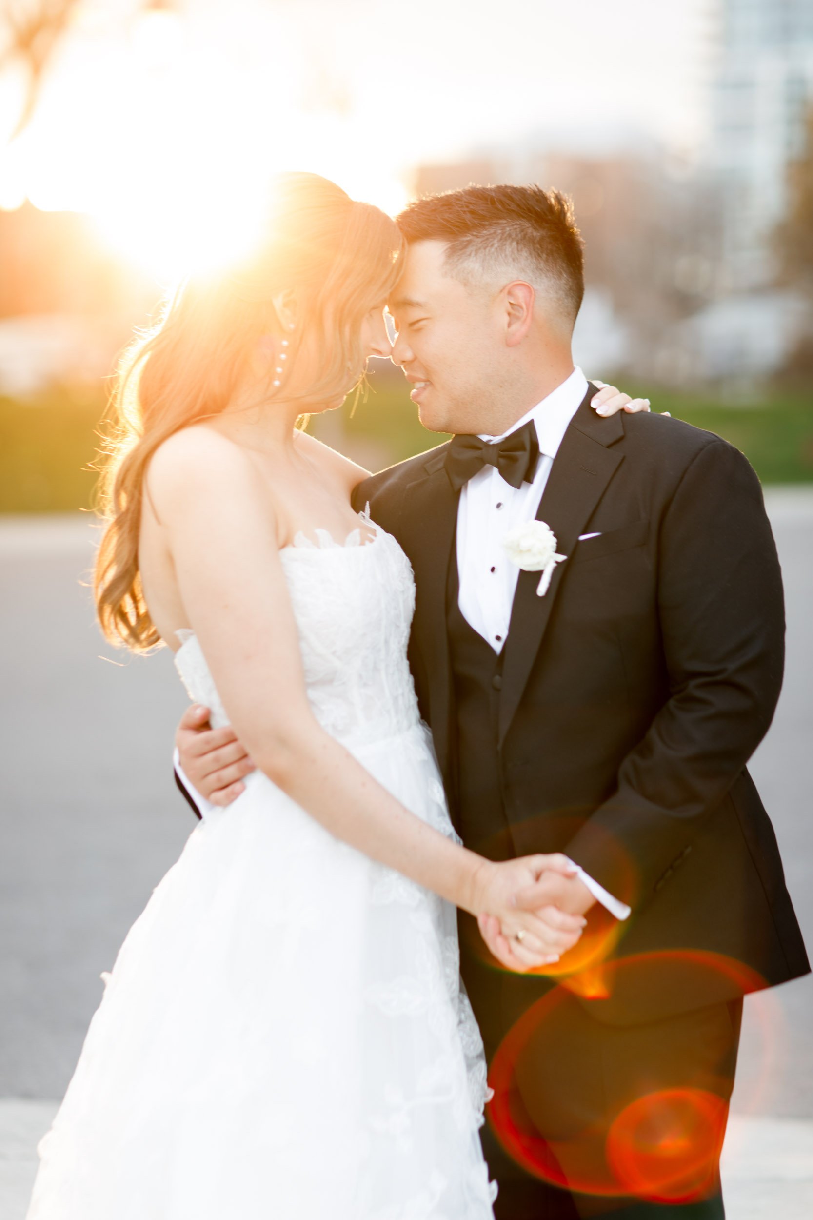 Bride and groom holding hands at sunset near the Pearle Hotel in Burlington Ontario