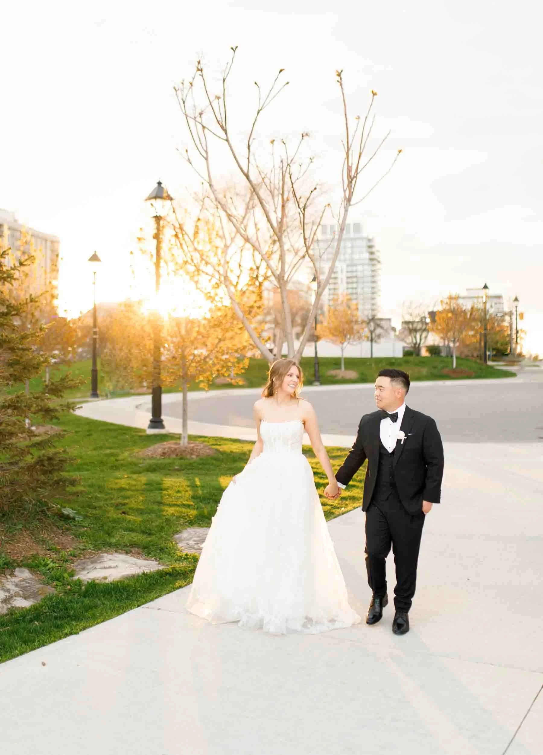Bride and groom walking at sunset hand in hand near the Pearle Hotel in Burlington Ontario
