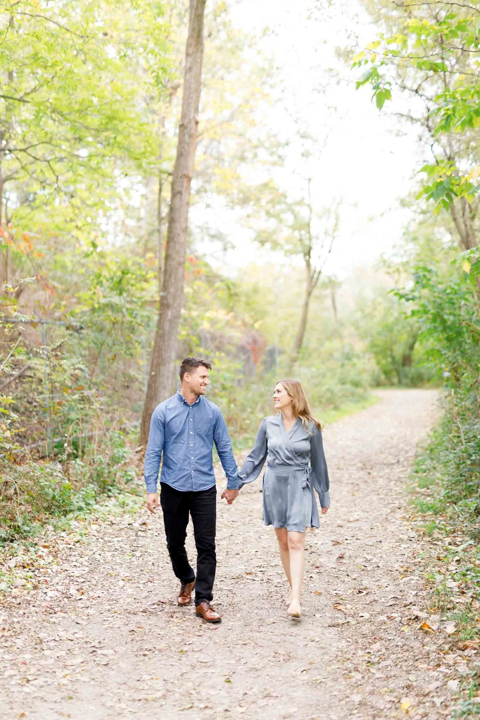 Couple walking together on a forest path during an engagement shoot at Grindstone Marsh Trail in Burlington Ontario