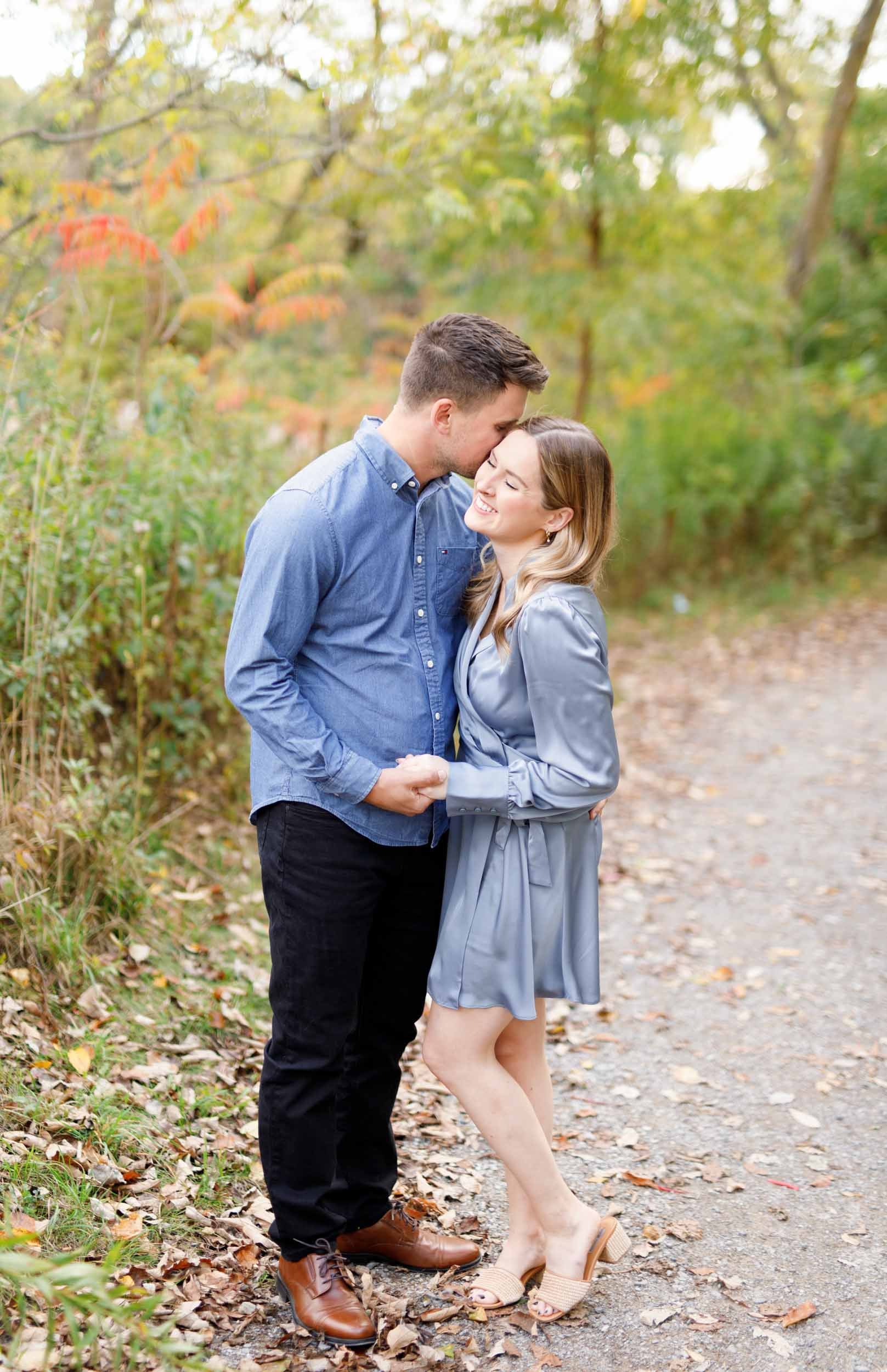 Romantic engagement photo of a couple standing together on a trail at Grindstone Marsh Trail in Burlington Ontario