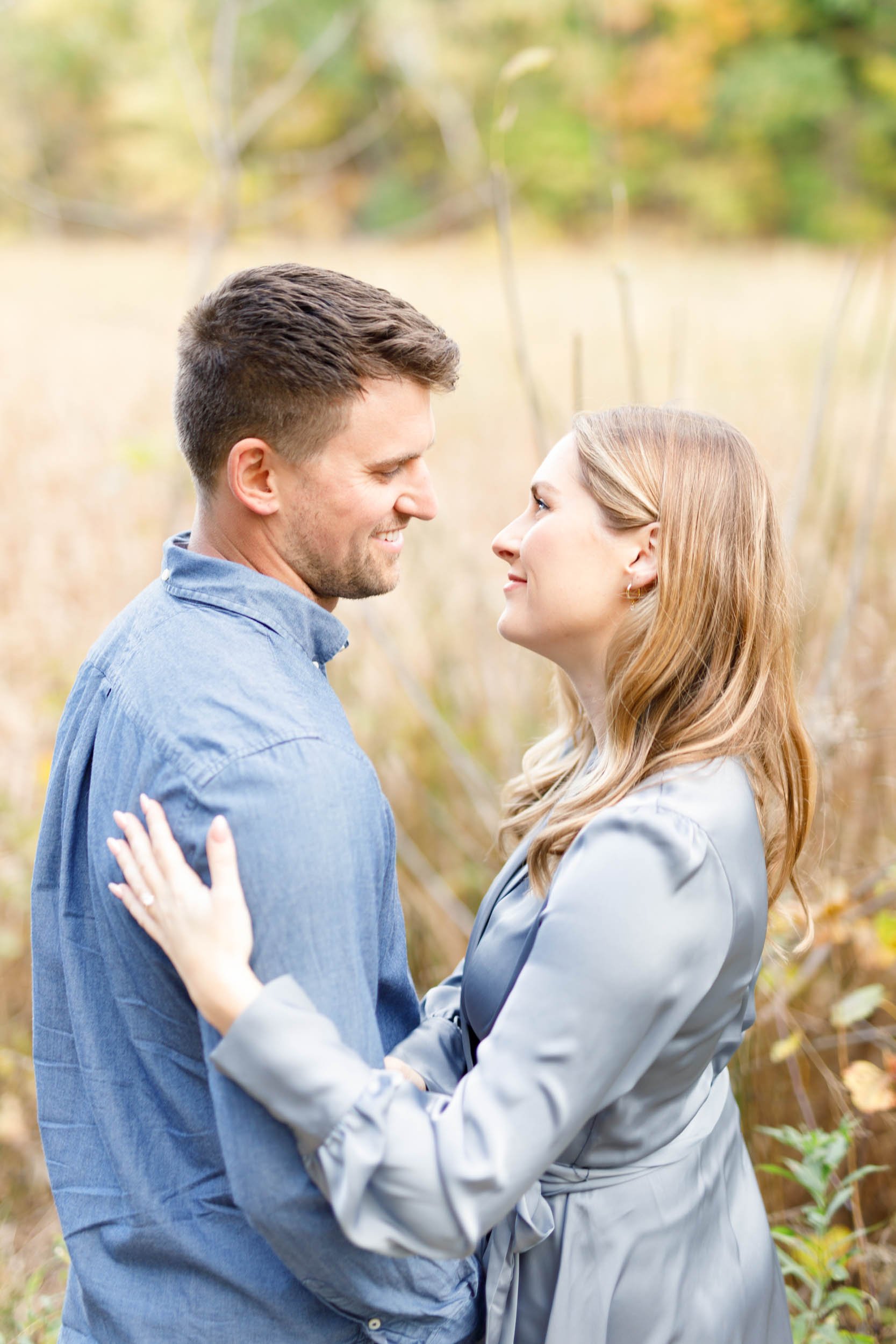 Romantic engagement photo of a couple facing each other at Grindstone Marsh Trail in Burlington Ontario