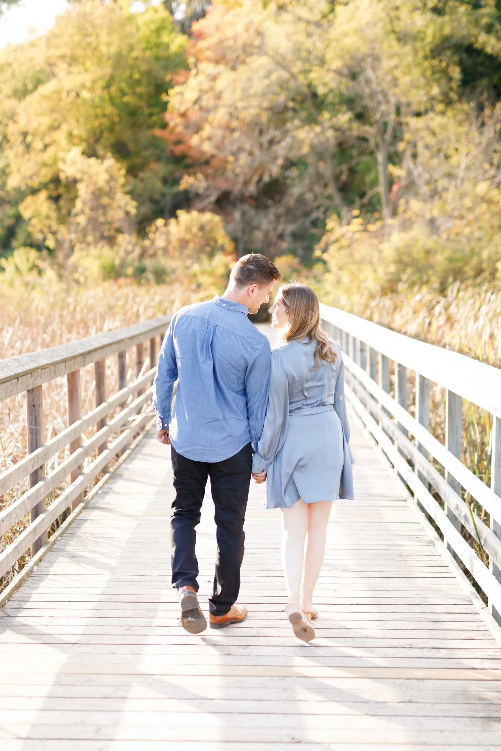 Couple walking away together during an engagement session at Grindstone Marsh Trail in Burlington Ontario
