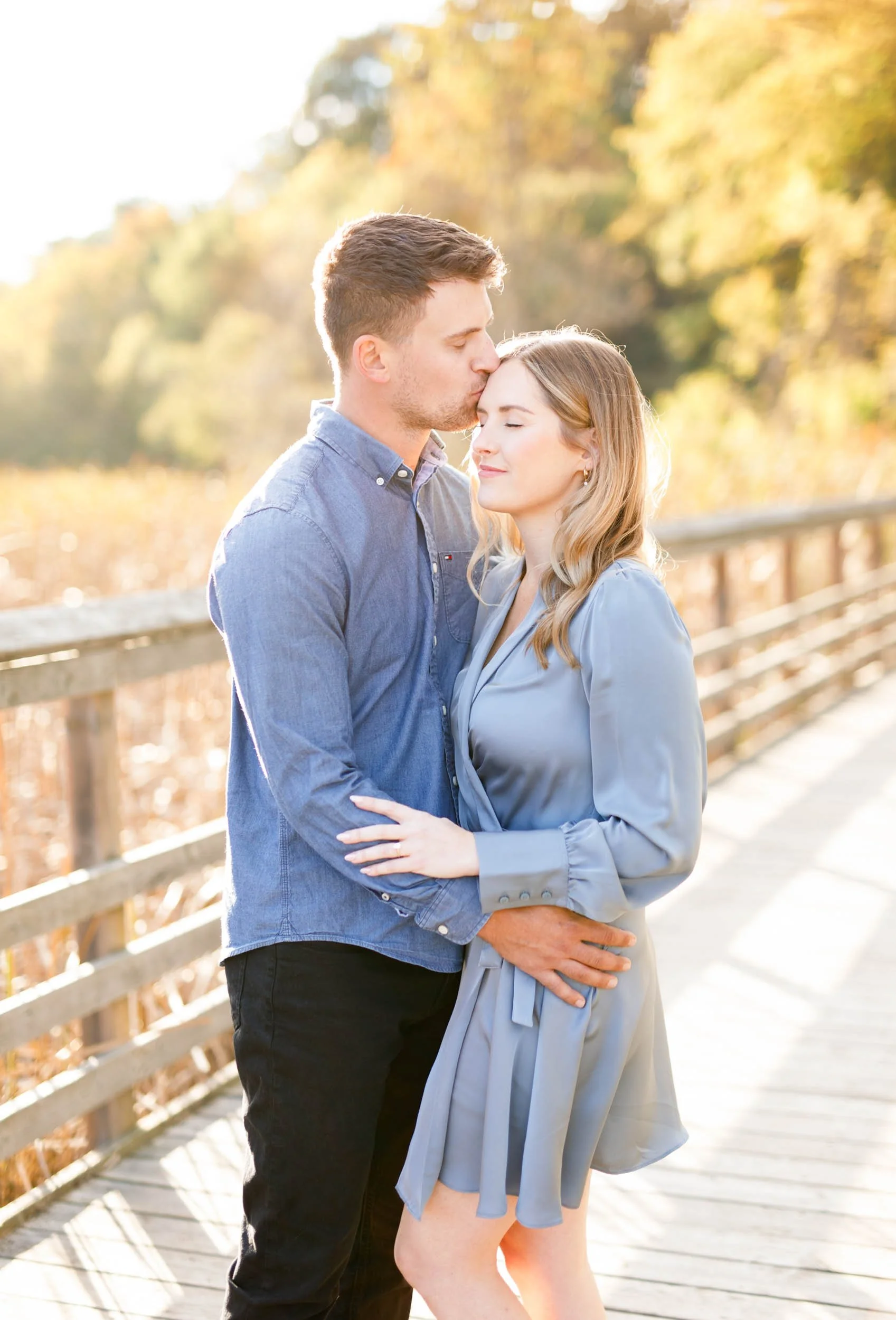 Romantic fall engagement photo of a couple standing close together at Grindstone Marsh Trail in Burlington Ontario