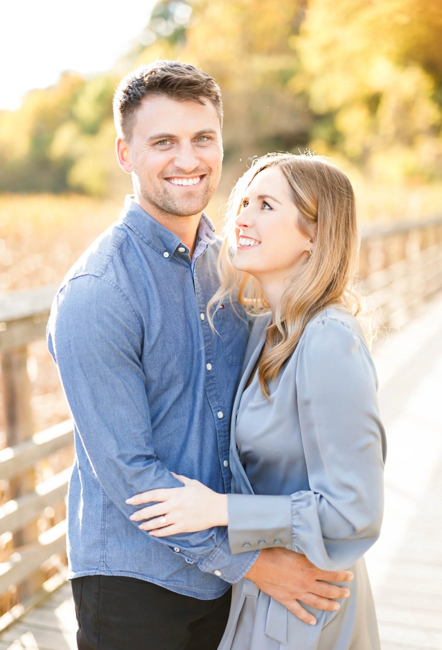 Happy engaged couple on the boardwalk at Grindstone Marsh Trail in Burlington Ontario during an outdoor engagement session