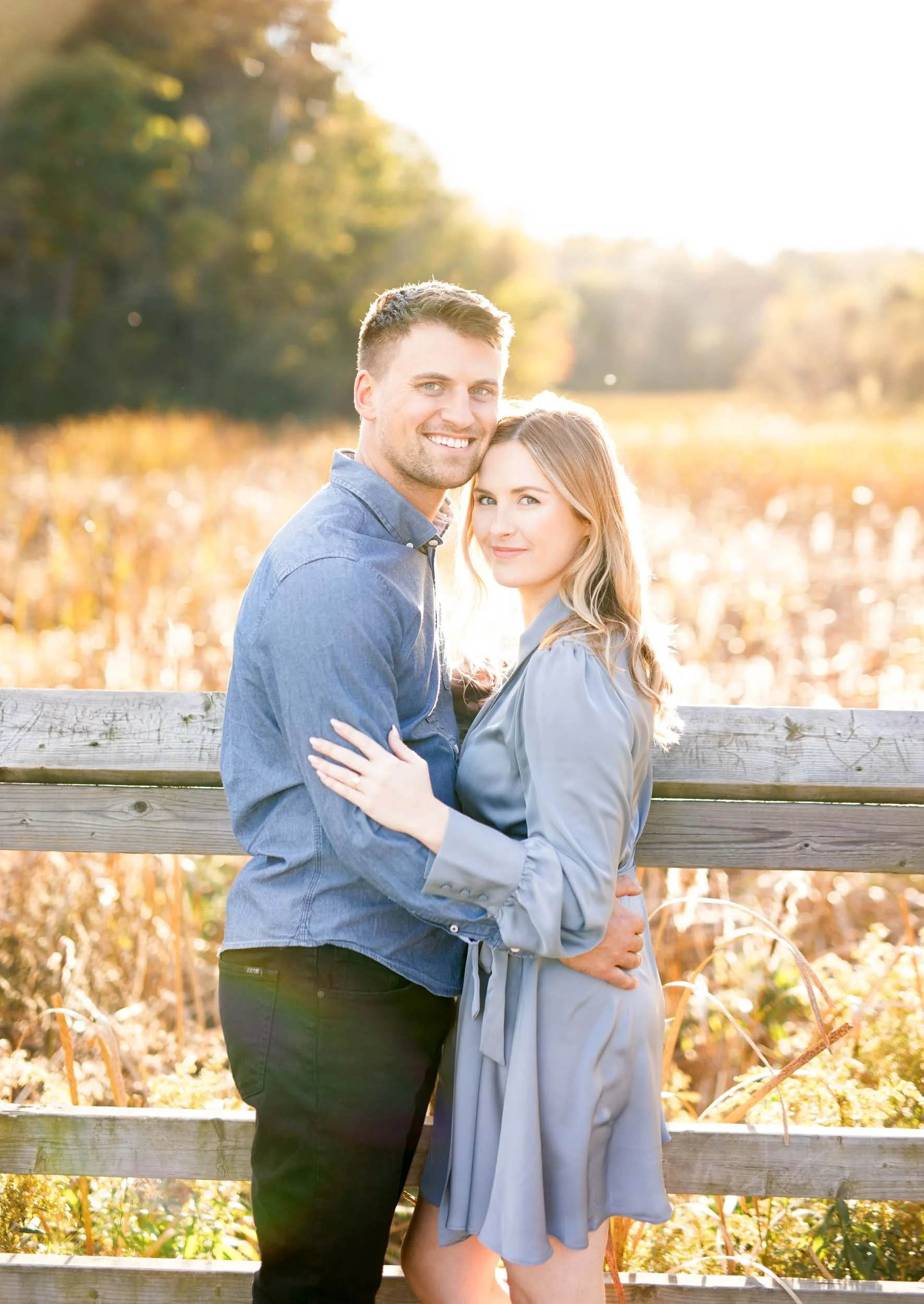 Romantic engagement portrait of a couple holding each other on the boardwalk at Grindstone Marsh Trail in Burlington Ontario