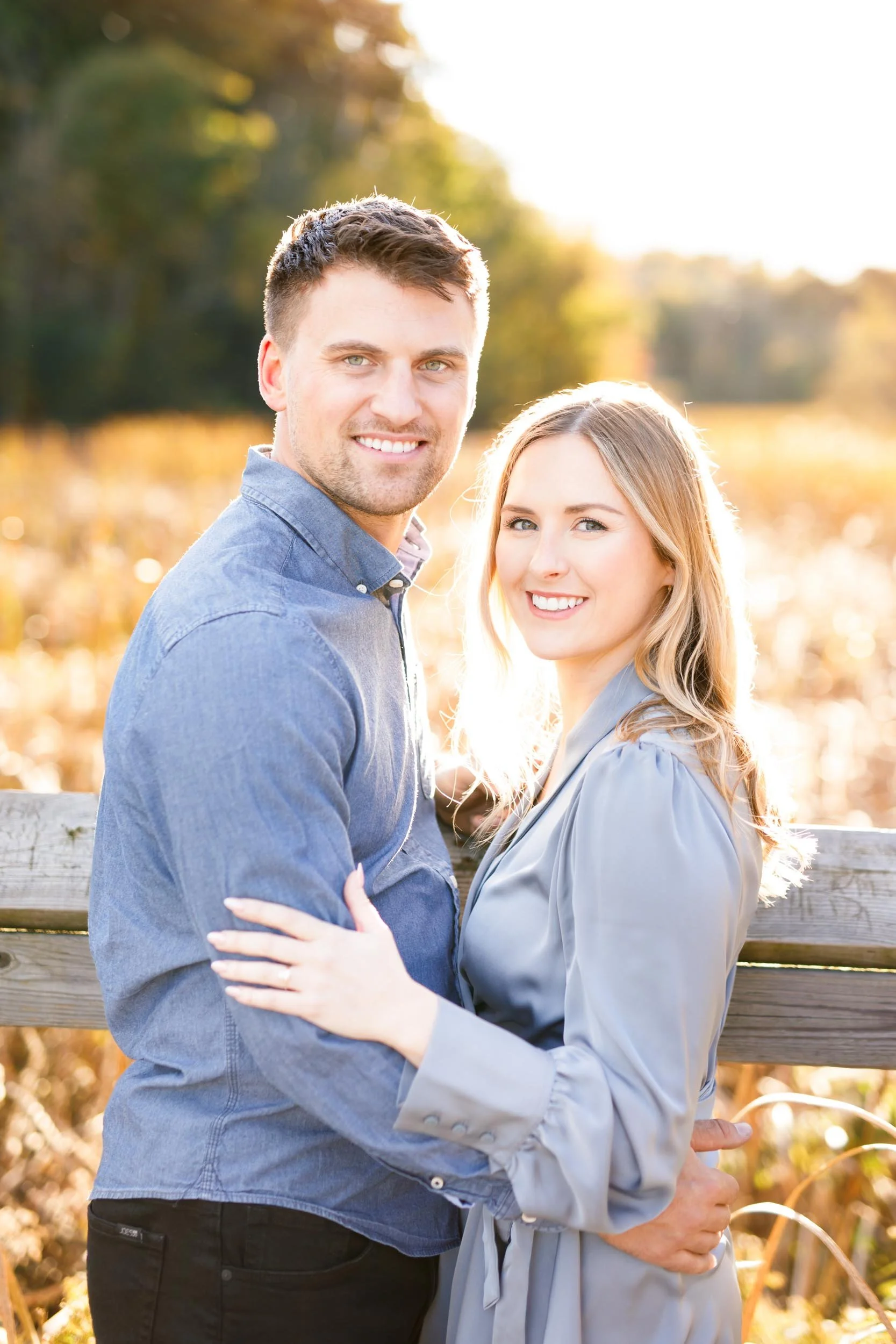 Smiling engaged couple posing together at Grindstone Marsh Trail in Burlington Ontario during a fall engagement shoot