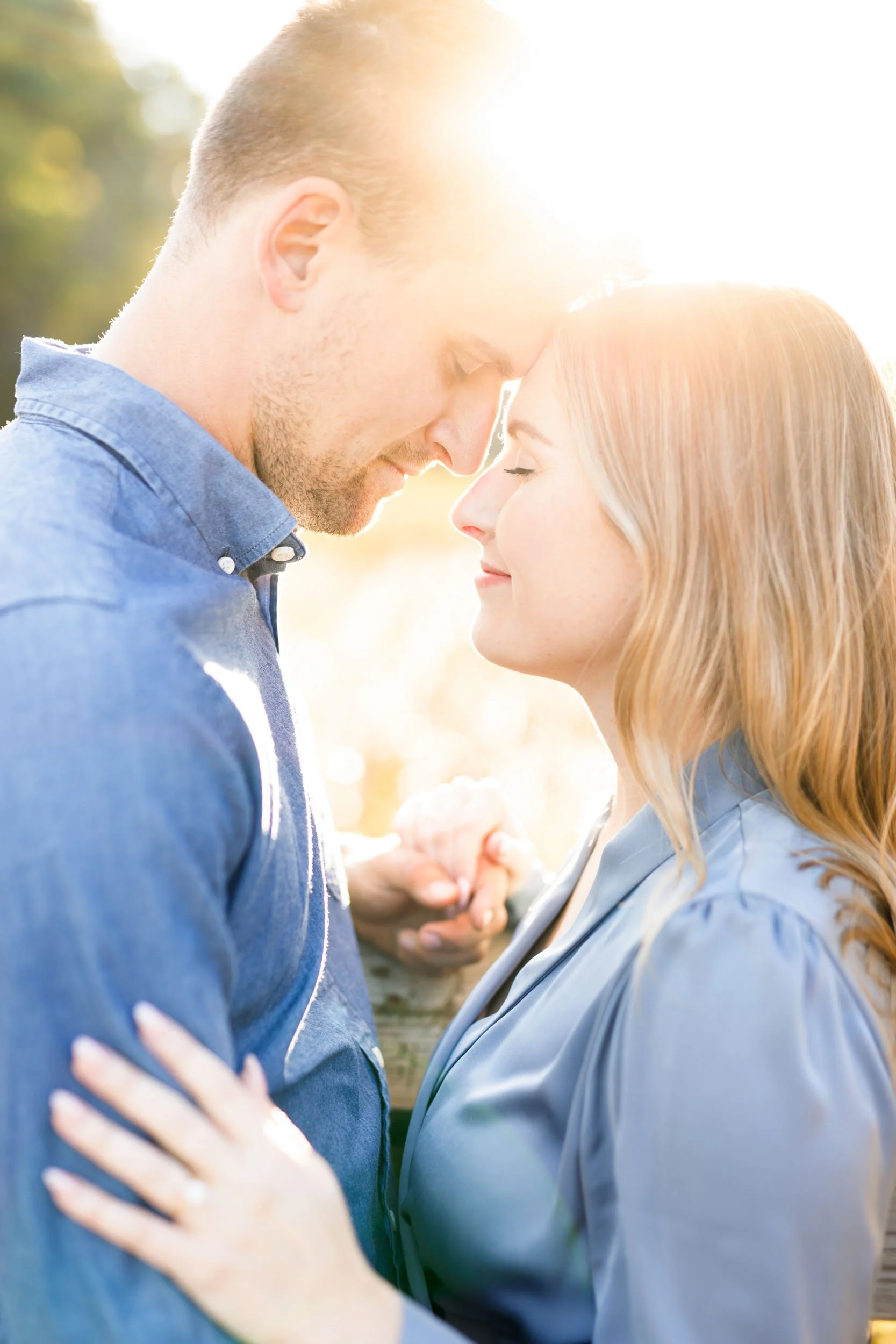 Bride to be smiling while holding her fiancé during an engagement shoot at Grindstone Marsh Trail in Burlington Ontario