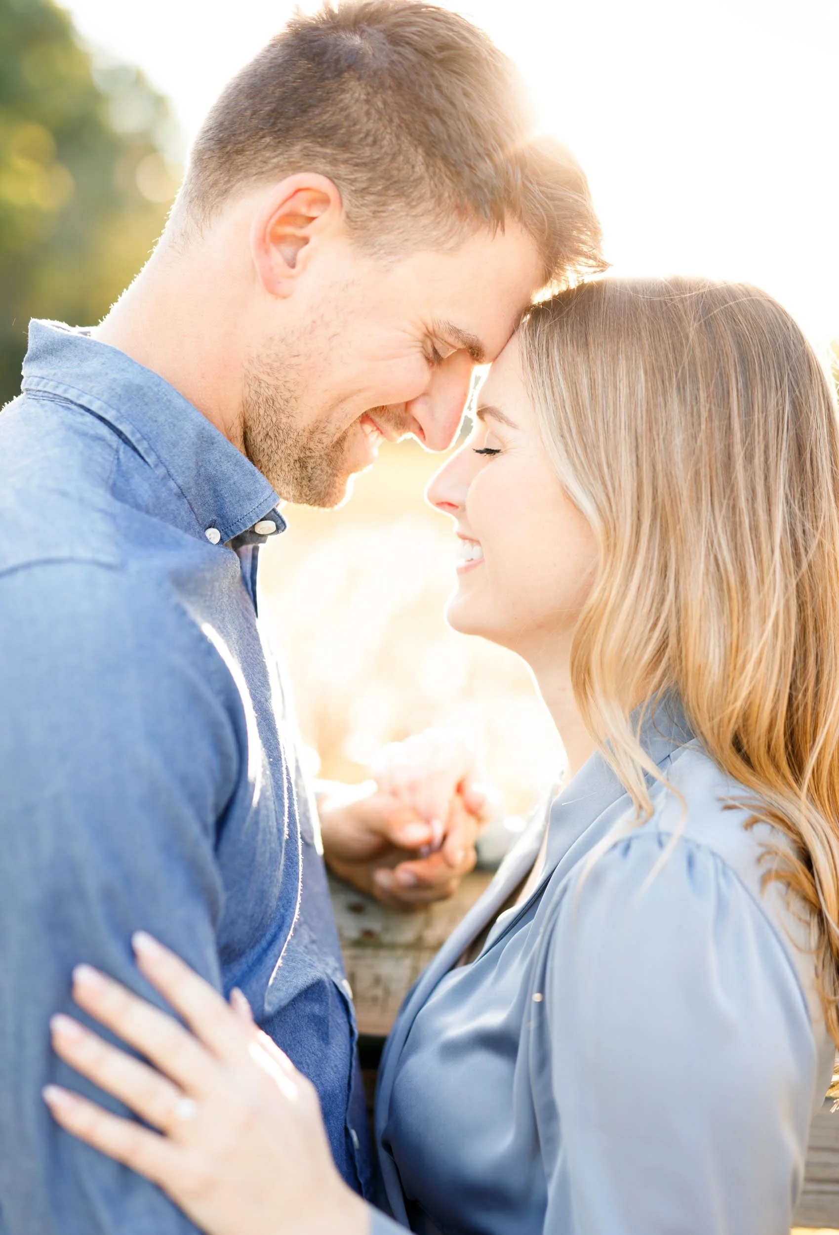 Engaged couple touching foreheads during a fall engagement session at Grindstone Marsh Trail in Burlington Ontario