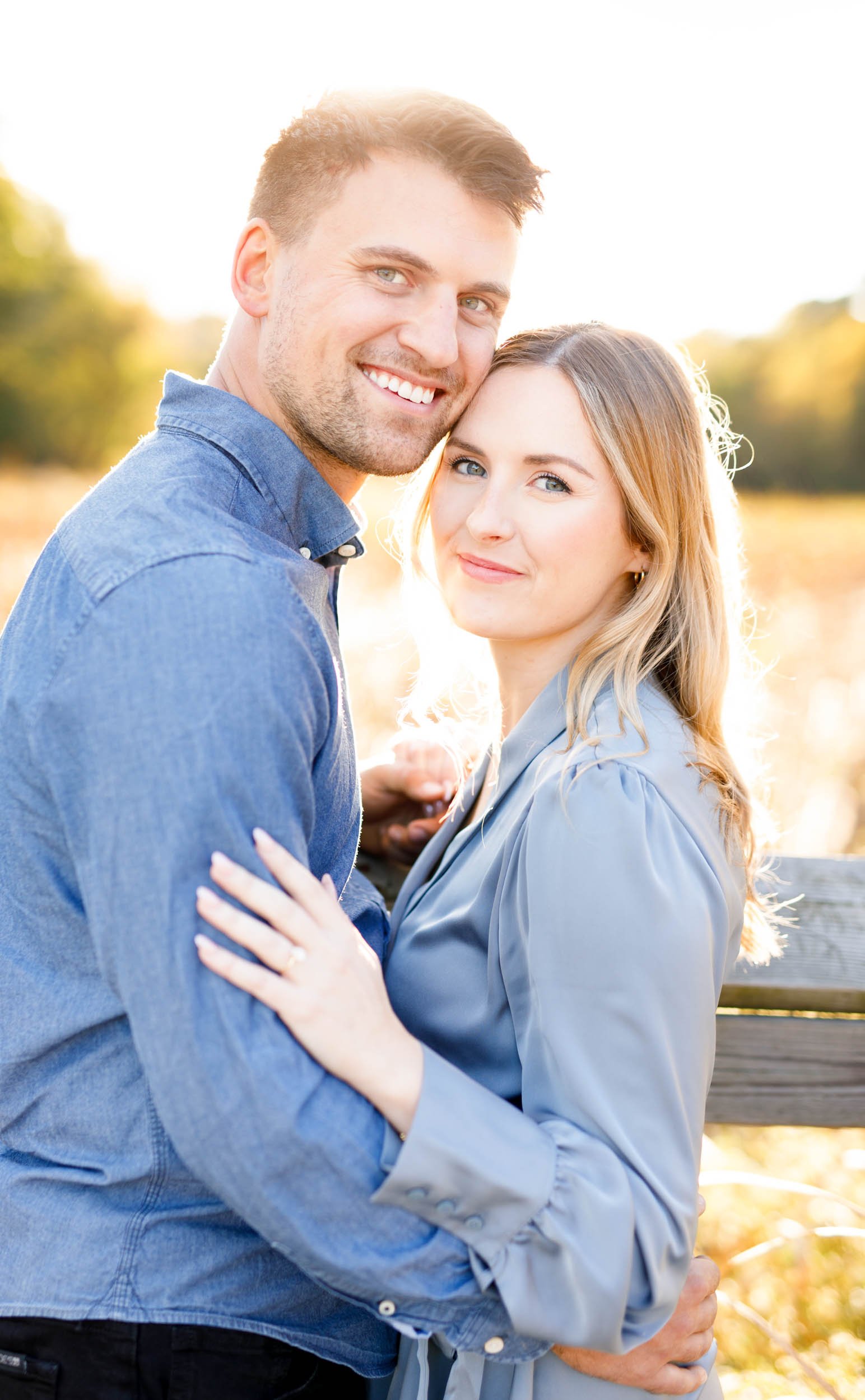 Couple embracing during a sun-drenched engagement session at Grindstone Marsh Trail in Burlington, Ontario