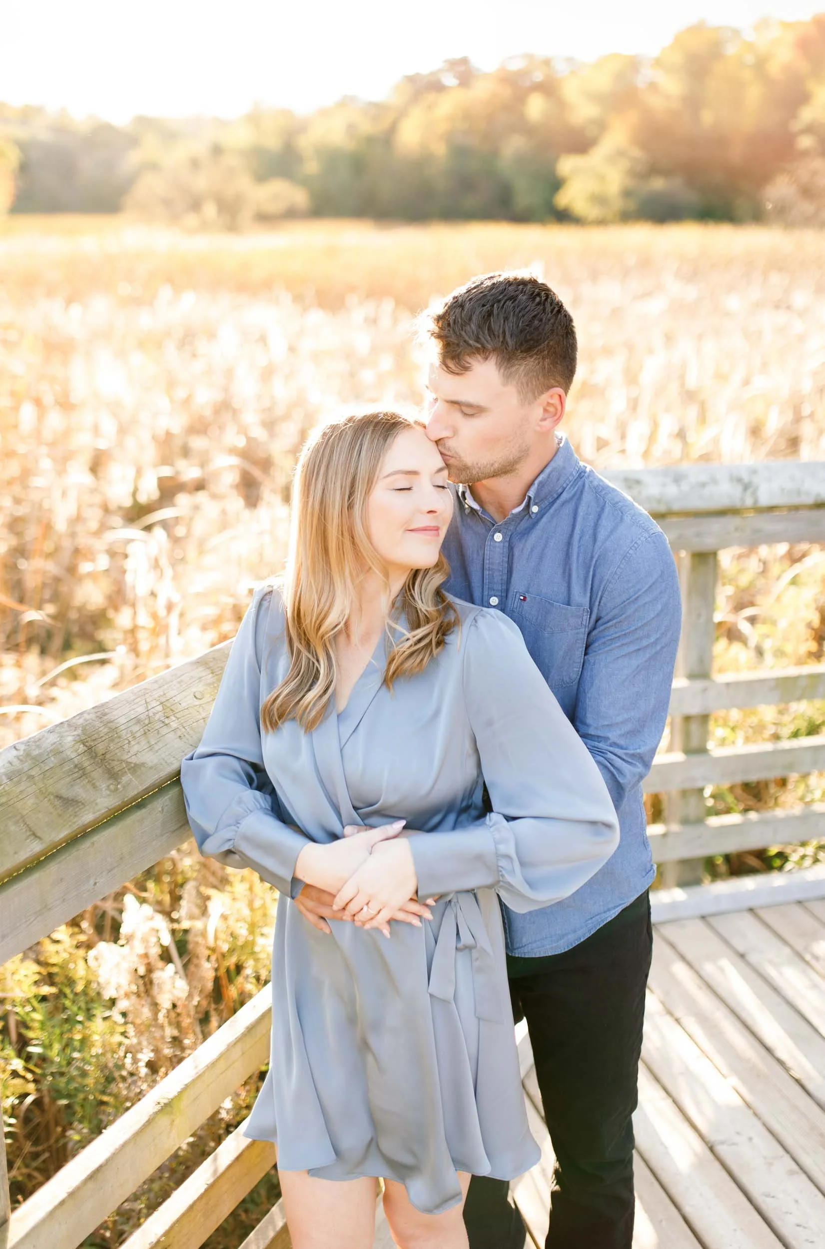Romantic engagement photo of a couple embracing at Grindstone Marsh Trail in Burlington Ontario during golden hour