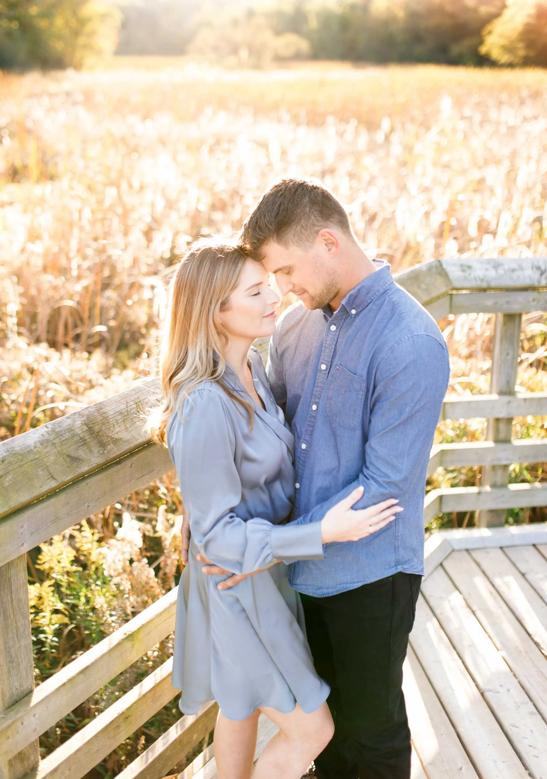 Couple holding each other during a fall engagement session at Grindstone Marsh Trail in Burlington Ontario