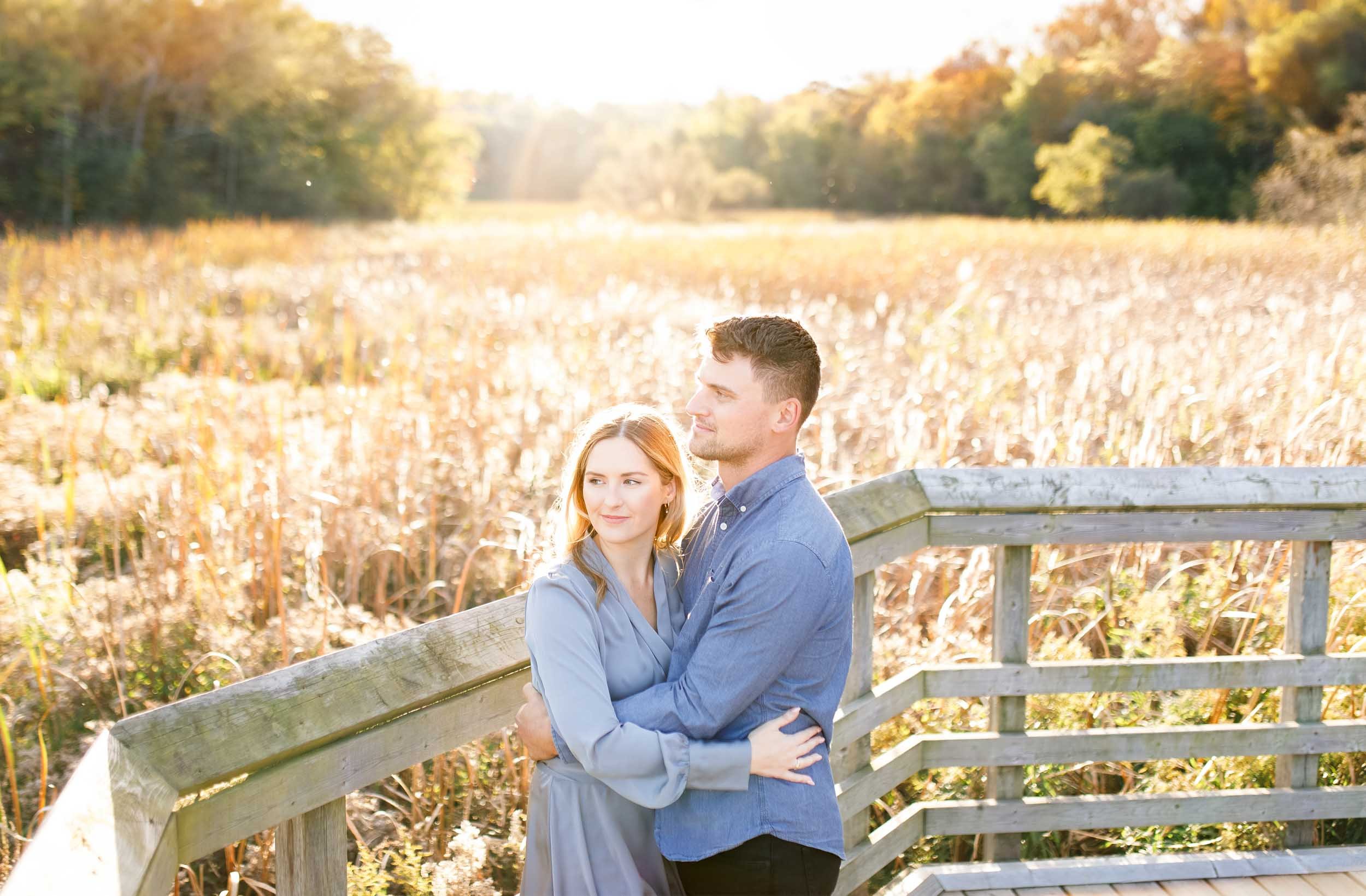 Romantic engagement portrait of a couple on the boardwalk at Grindstone Marsh Trail in Burlington Ontario