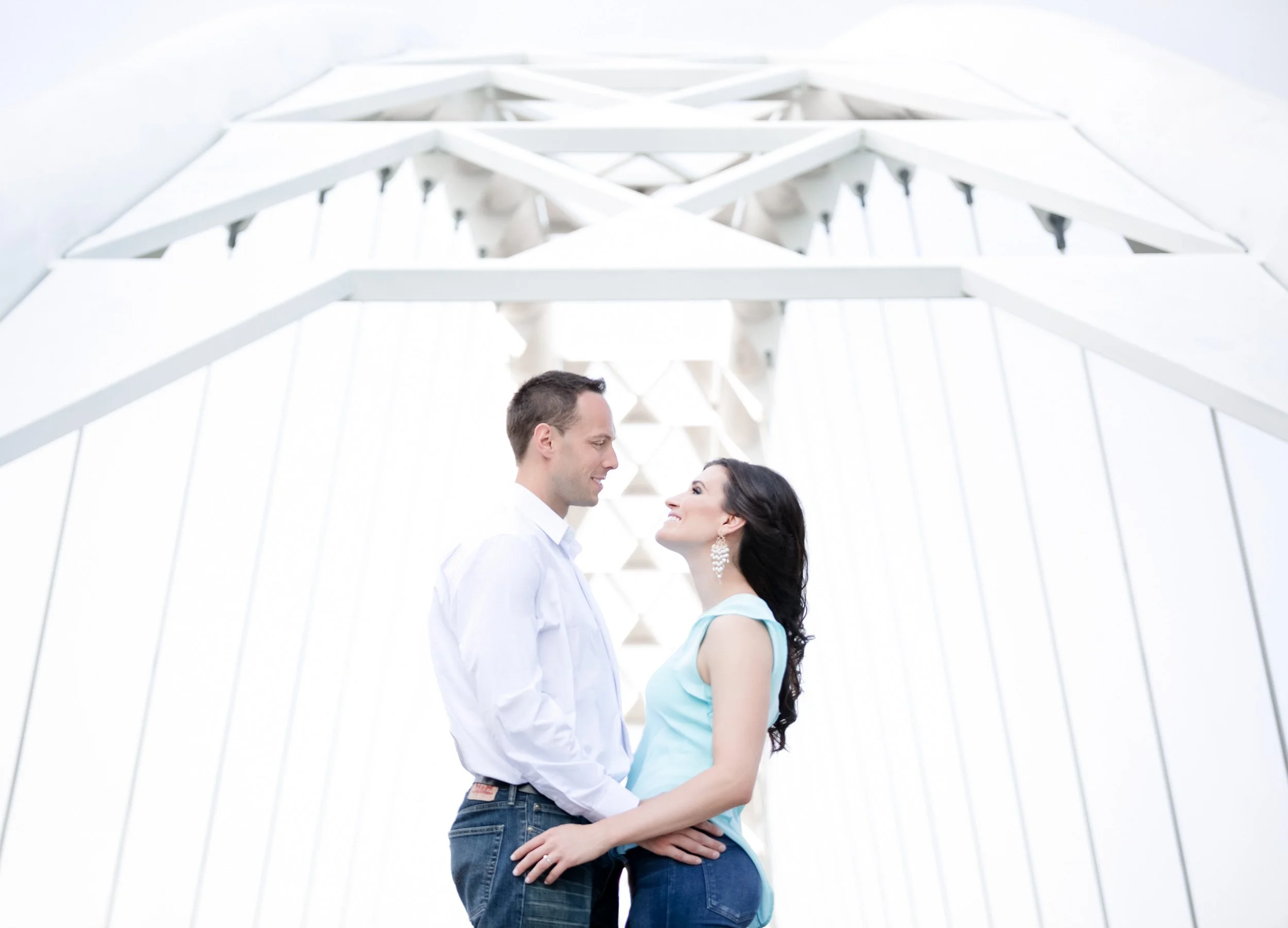 Wide cinematic romantic engagement photo of a couple at Humber Bay Arch Bridge in Toronto, Ontario
