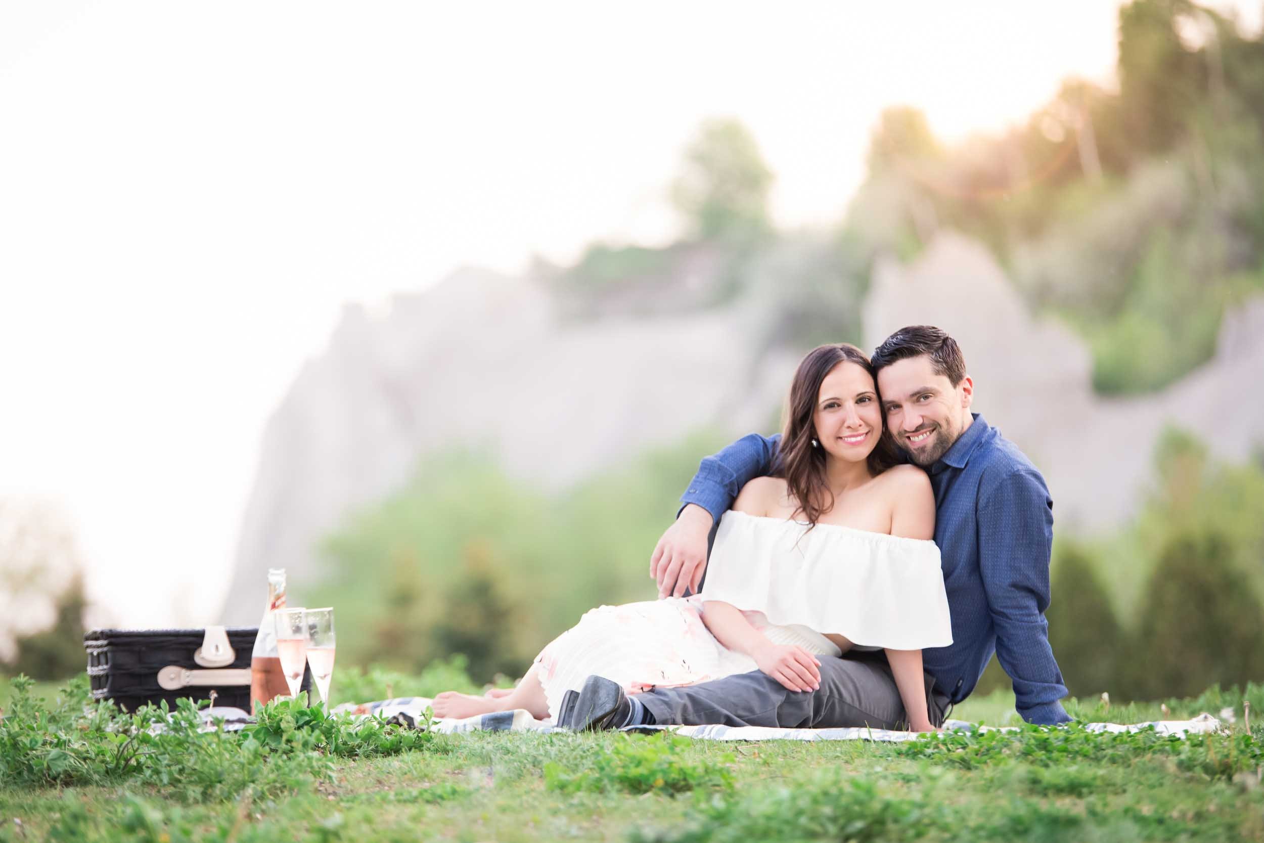 Couple seated picnic together on the grass during a relaxed Scarborough Bluffs engagement session (Copy)