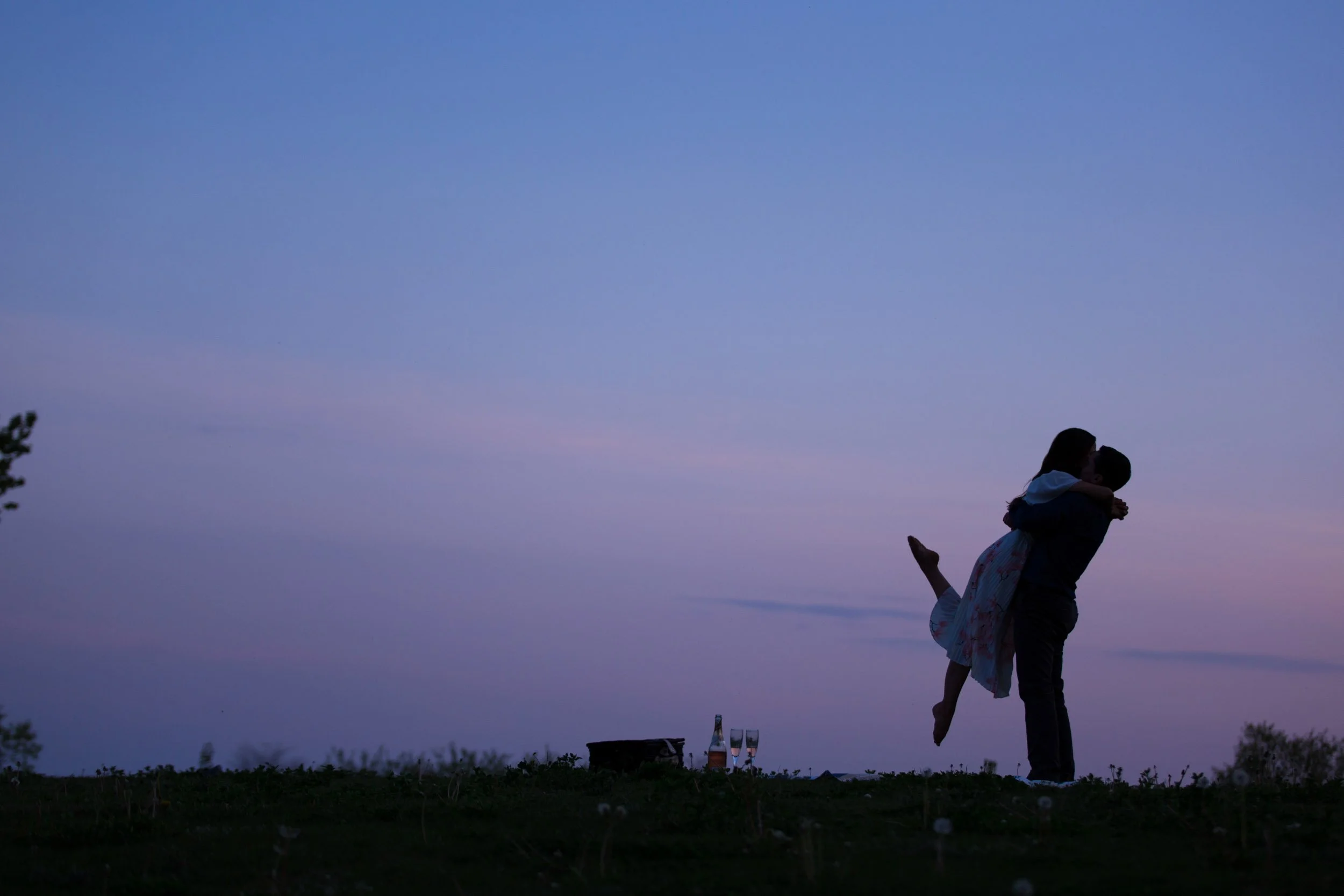 Playful engagement silhouette photo of a couple lifting each other at dusk in Toronto (Copy)