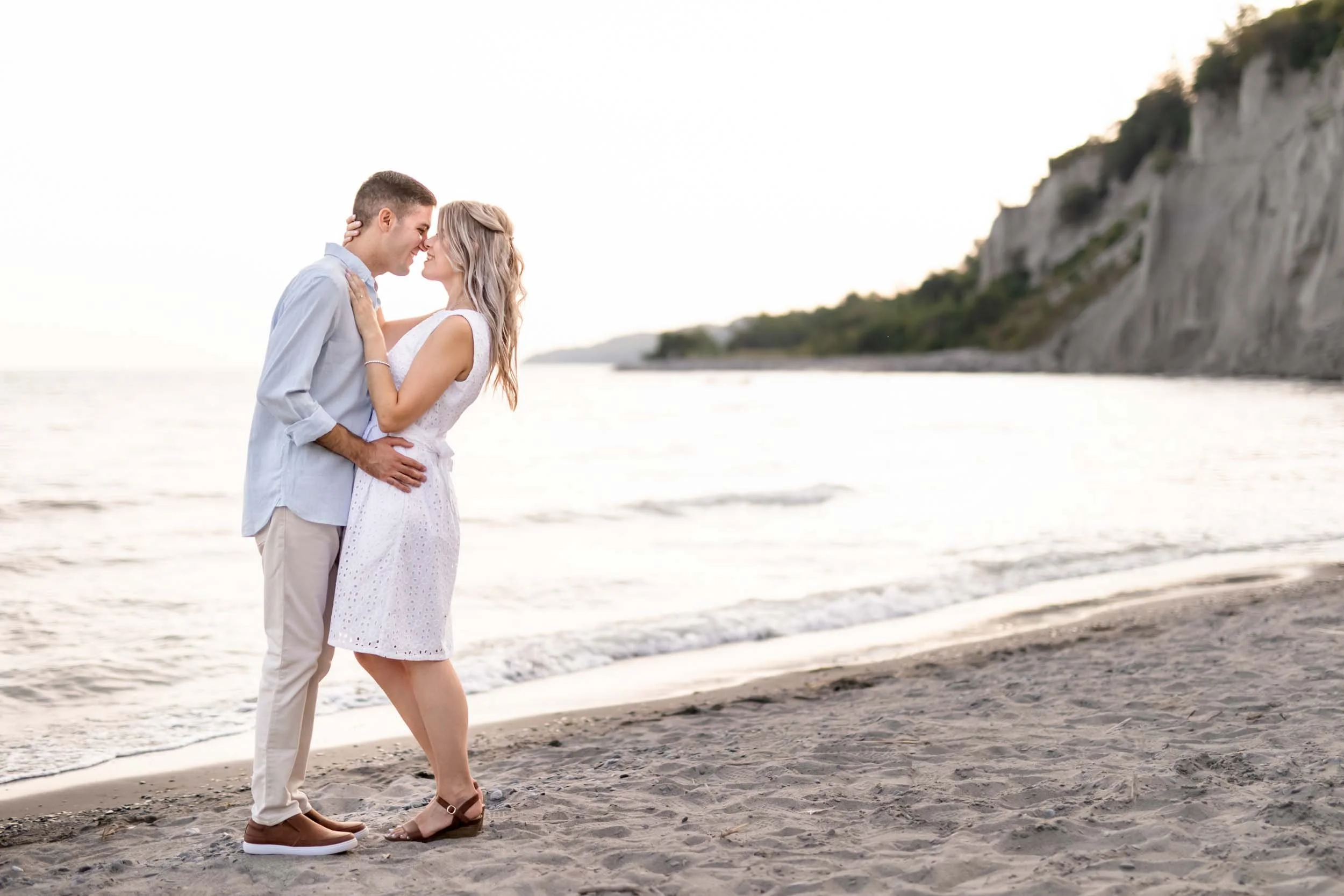 Engaged couple embracing on the shoreline at the Scarborough Bluffs in Toronto (Copy)